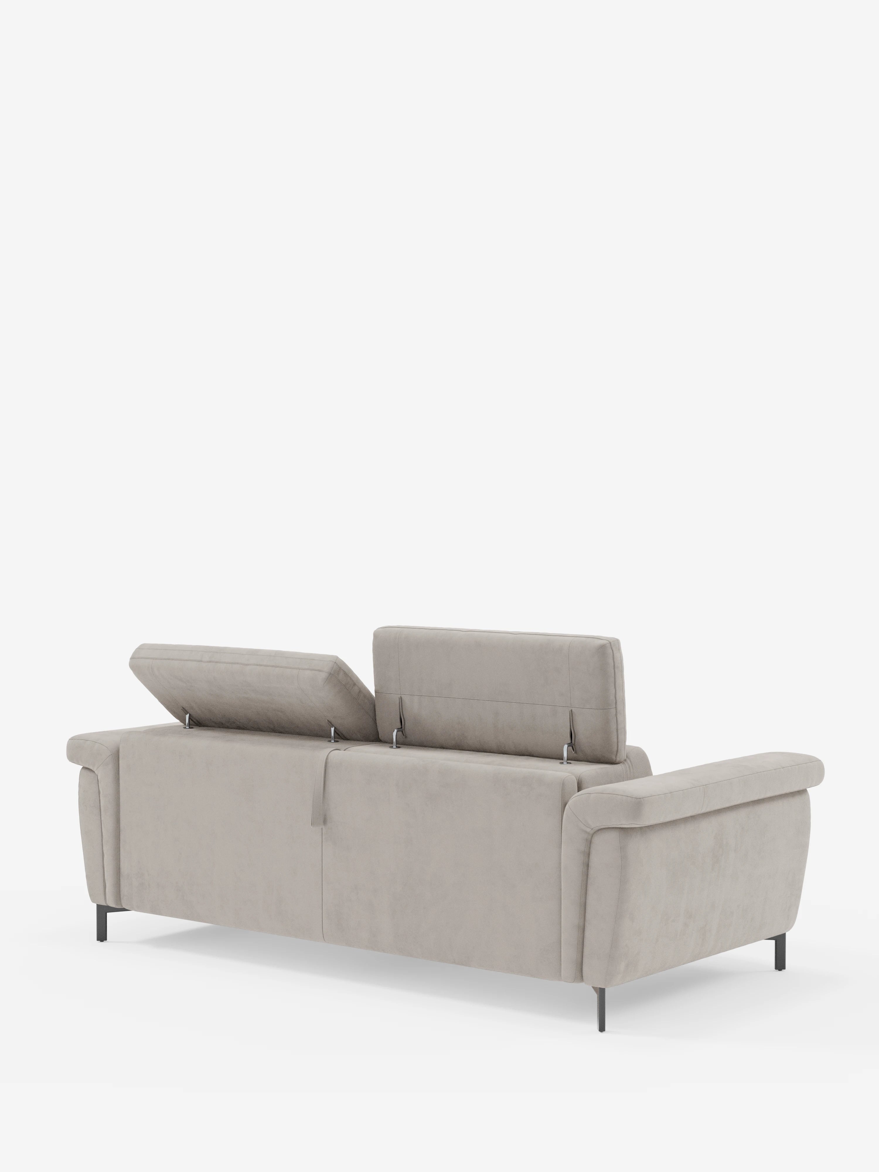 Un divano letto di design Capri color beige chiaro con piedini alti di Divani.Store, rivestito in raffinato tessuto effetto velluto antimacchia (T30), con due poggiatesta reclinabili parzialmente rialzati. Il divano presenta braccioli arrotondati, un'imbottitura morbida, sottili gambe nere ed è posto su uno sfondo bianco a tinta unita per un look moderno e funzionale.