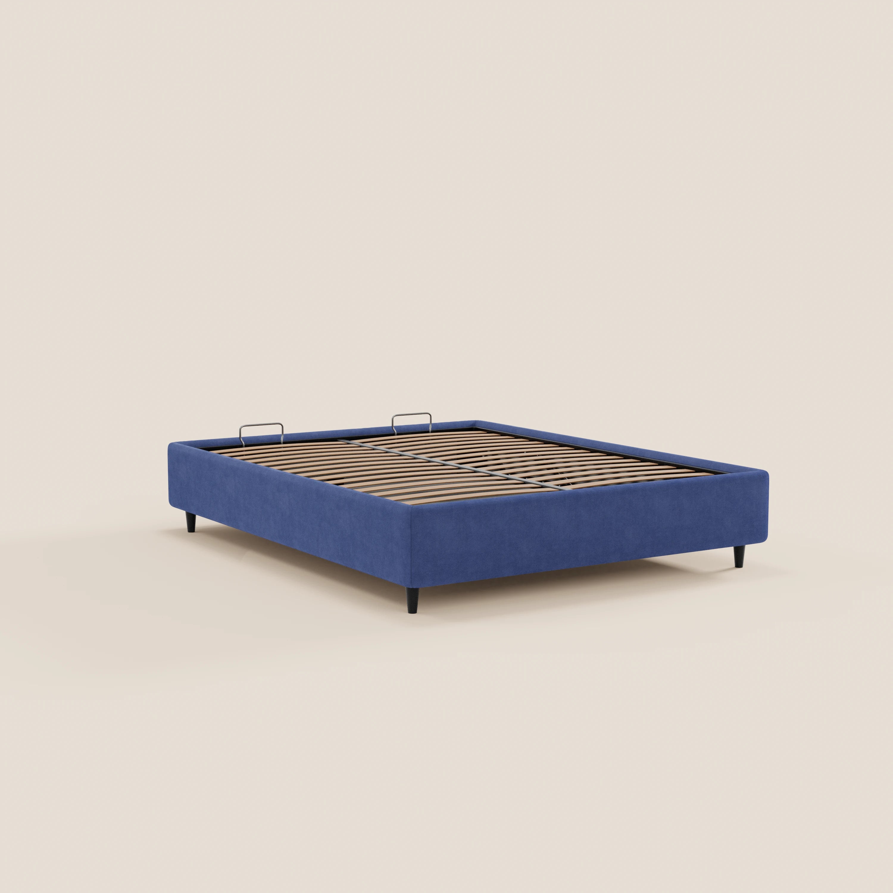 Il letto sommier imbottito ERON di Letti.store presenta una base in tessuto blu impermeabile certificato Oeko-Tex, doghe in legno, gambe nere e due staffe metalliche nella zona della testata. Il tutto su uno sfondo beige chiaro. Materasso non incluso.