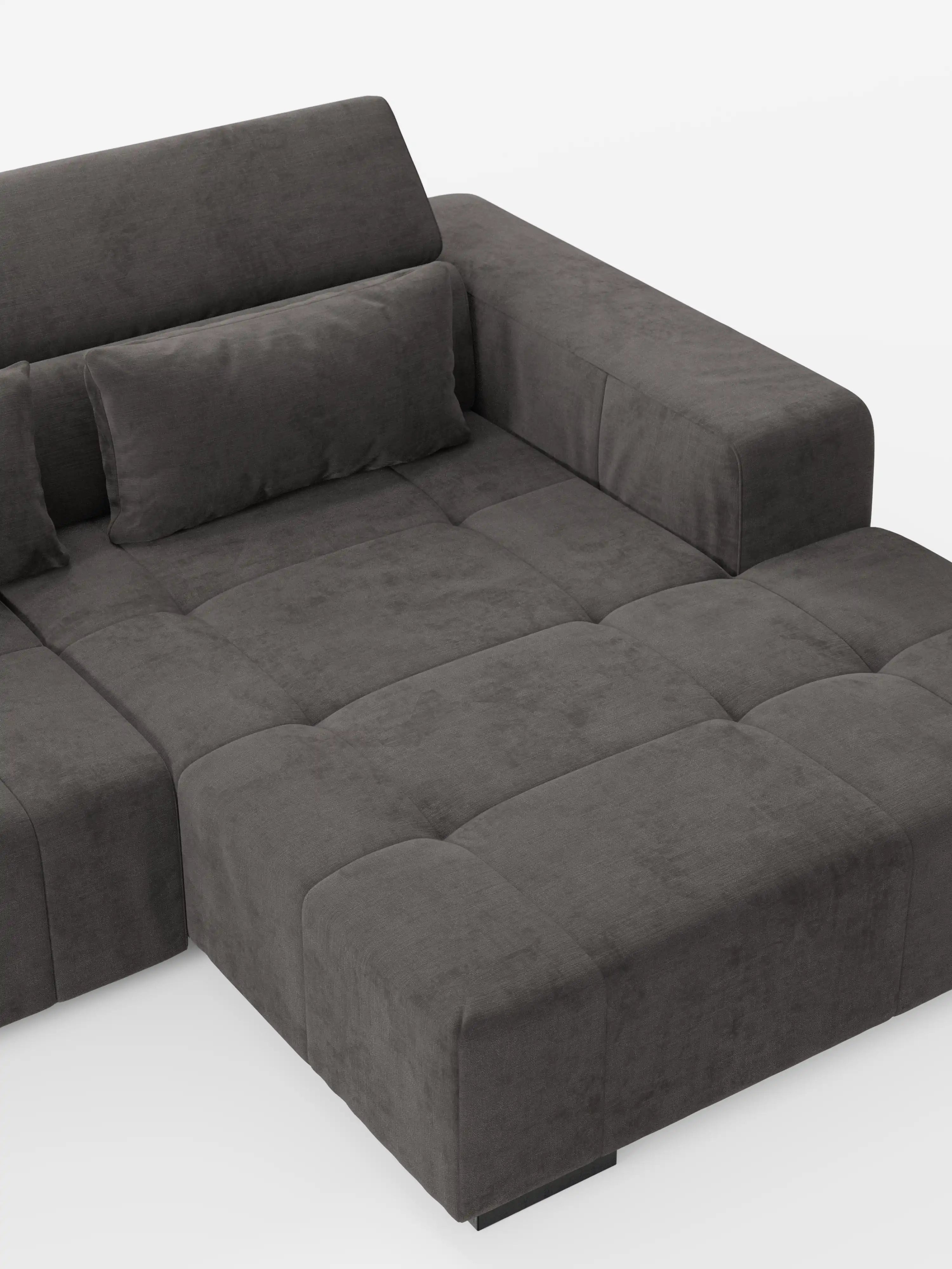 Il divano angolare Monarch con penisola e funzione Relax Elettrico per l’allungamento delle sedute di Divani.Store è un moderno divano componibile in grigio scuro, caratterizzato da un design squadrato con trapuntatura e da braccioli ampi e bassi. Rivestito in morbido tessuto T31 resistente alle macchie, è dotato di poggiatesta reclinabili regolabili per un comfort ancora maggiore. Un cuscino rettangolare impreziosisce lo schienale. Il divano è raffigurato su uno sfondo bianco a tinta unita.