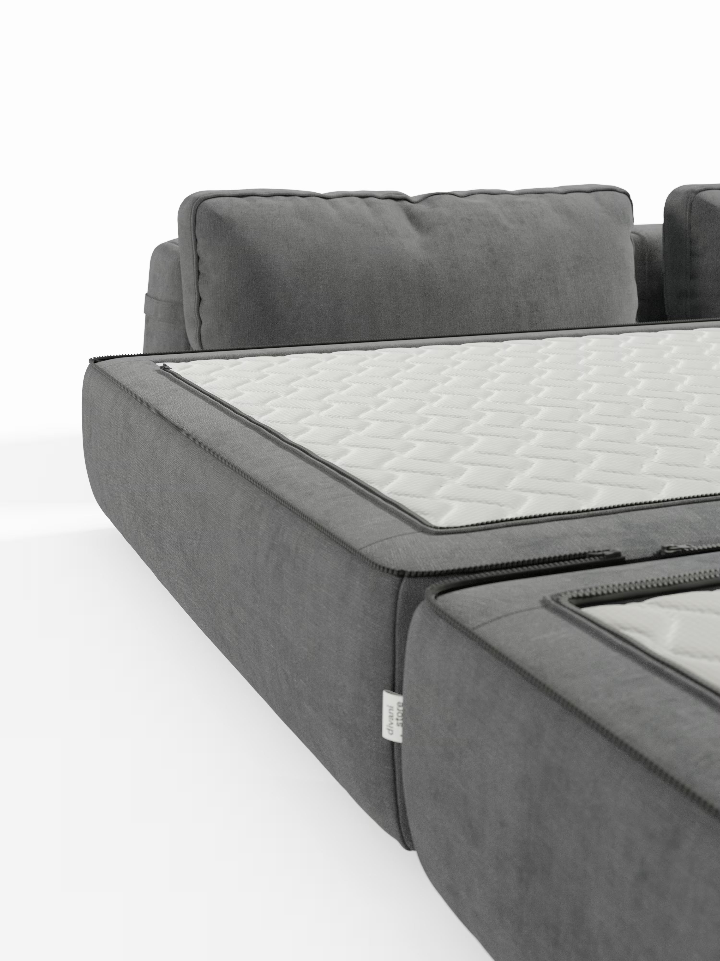 Primo piano di un moderno divano letto matrimoniale Rift grigio a 2 e 3 posti con schienali mobili di Divani.Store, dotato di un materasso bianco trapuntato in memory foam T31 alto 22 cm, parzialmente aperto tramite cerniera e disteso per rivelare la sua funzione letto nascosta. Lo sfondo bianco a tinta unita mette in risalto il design del divano letto trasformabile e il morbido rivestimento in tessuto, perfetto per chi cerca comfort e stile nell’innovativo divano letto moderno di Divani.Store.
