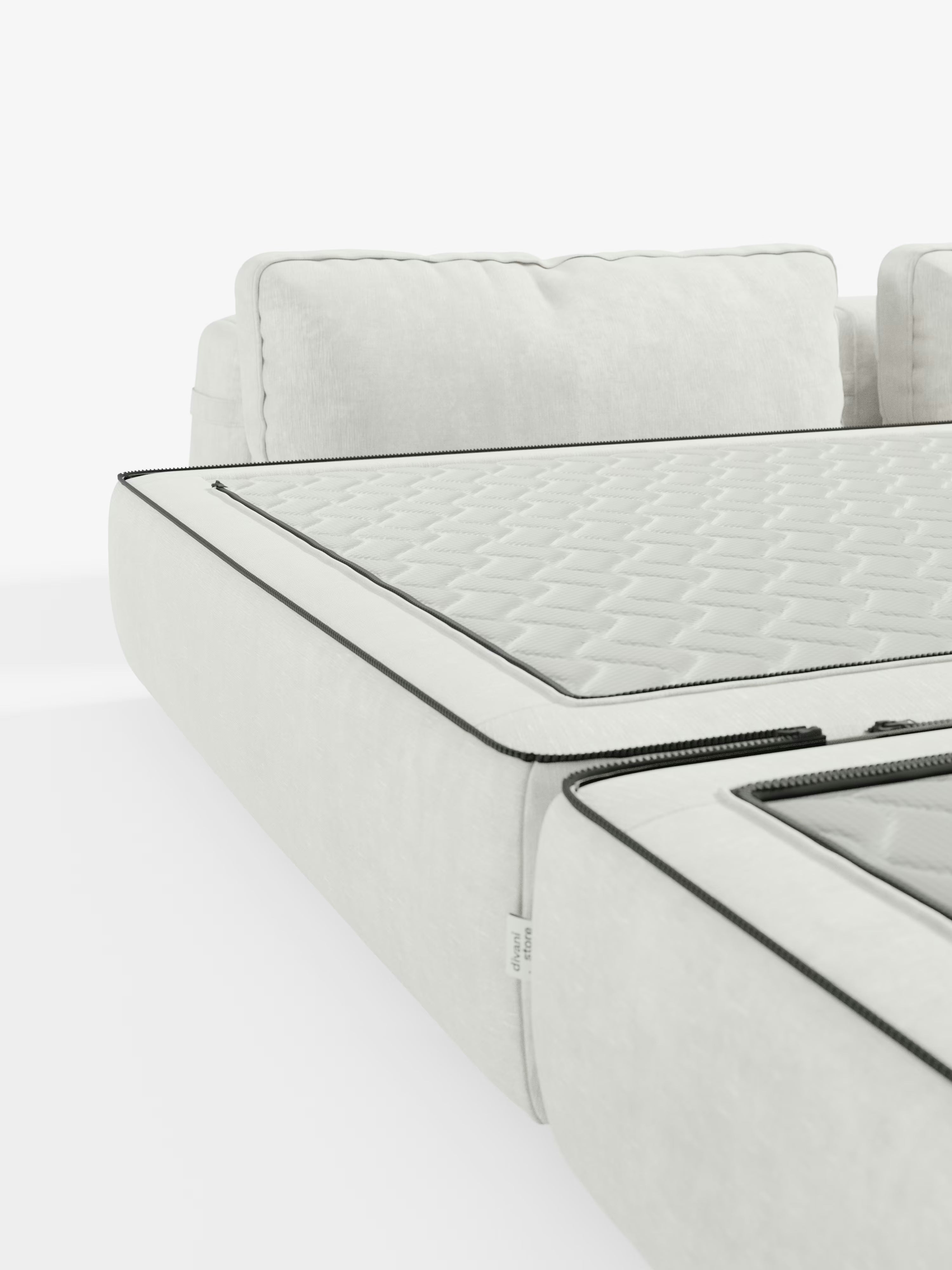 Un primo piano del divano letto matrimoniale Rift a 2 e 3 posti con schienali mobili di Divani.Store ne mette in risalto il design moderno in bianco con cuscini di seduta sfoderabili. I cuscini presentano una superficie trapuntata a trama e cerniere a vista con bordino nero, creando un look elegante e contemporaneo sullo sfondo bianco a tinta unita. Questo divano letto include un materasso in memory foam alto 24 cm rivestito in tessuto smacchiabile T31.