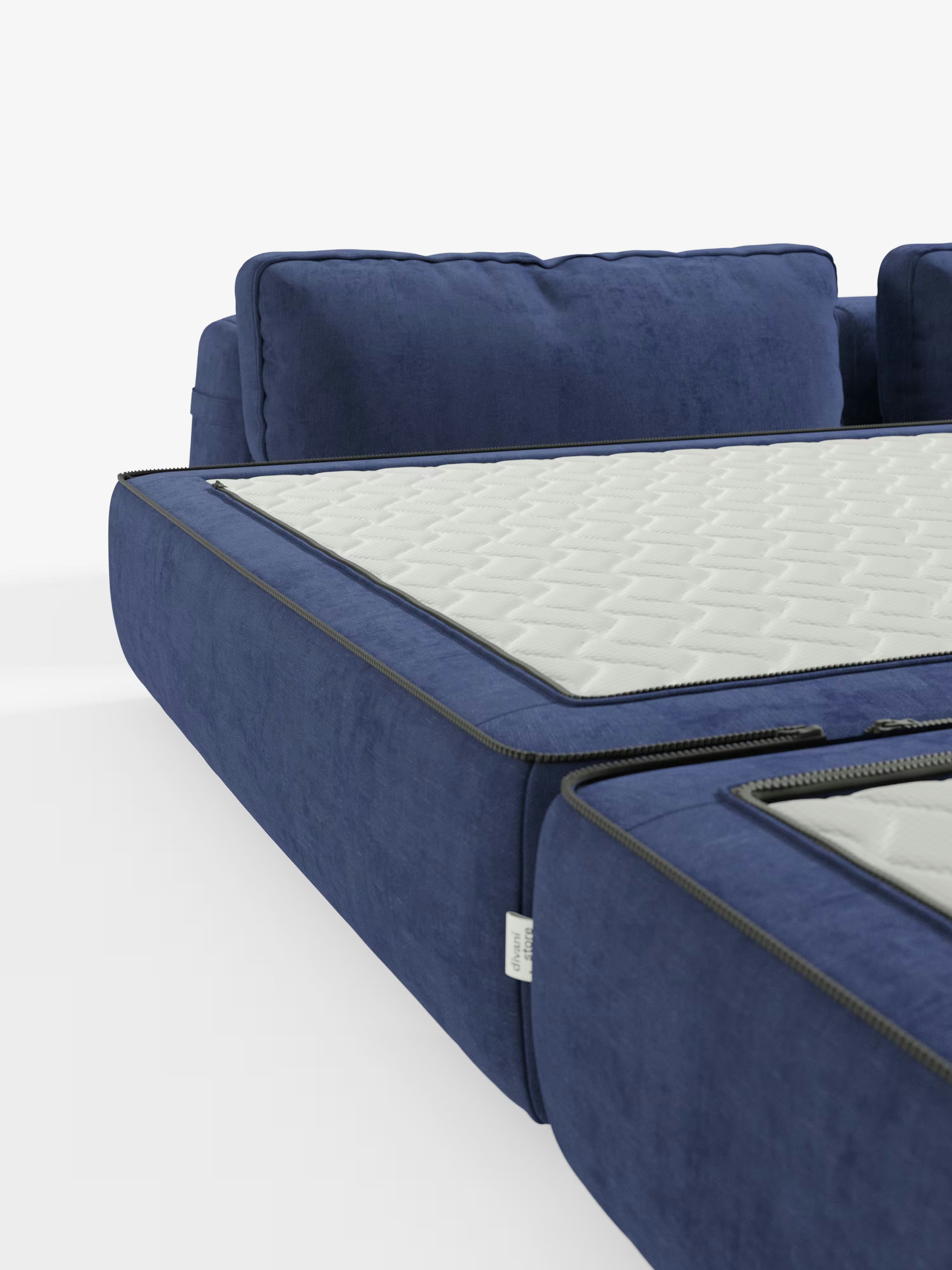 Un primo piano del divano letto matrimoniale Rift a 2 e 3 posti con schienali mobili di Divani.Modello in blu, dotato di un materasso bianco testurizzato alto 24 cm e in memory foam rivestito in tessuto smacchiabile T31, parzialmente aperto per mostrarne la trasformazione da divano a letto su uno sfondo bianco a tinta unita. Questo elegante divano di design è perfetto per valorizzare qualsiasi ambiente.