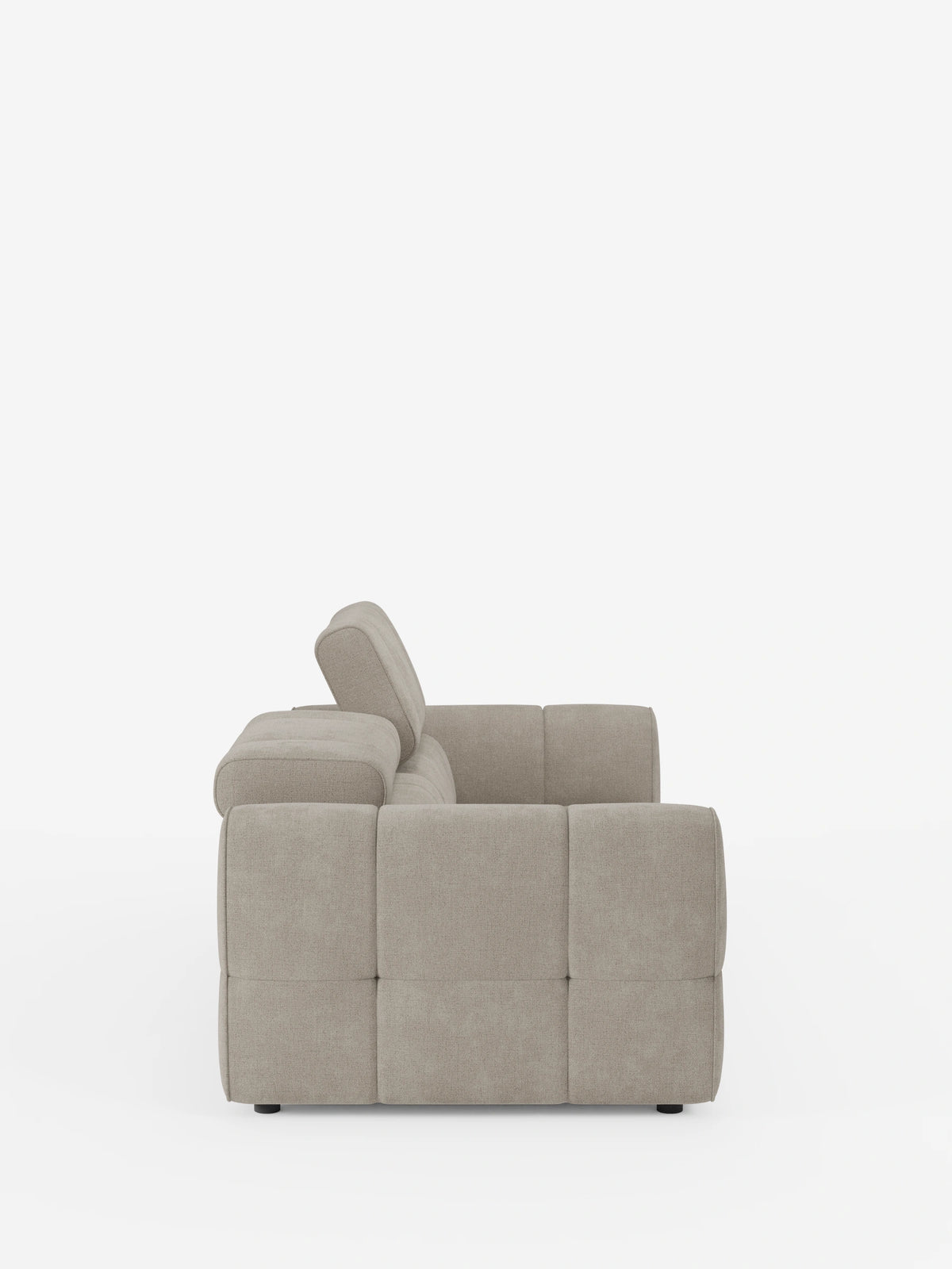 Vista laterale di un divano modulare Giotto a 3 posti color beige, con poggiatesta reclinabili e funzione relax elettrica opzionale, rivestito in tessuto smacchiabile T23; il modello presenta un design squadrato e trapuntato con braccioli bassi su uno sfondo bianco a tinta unita.