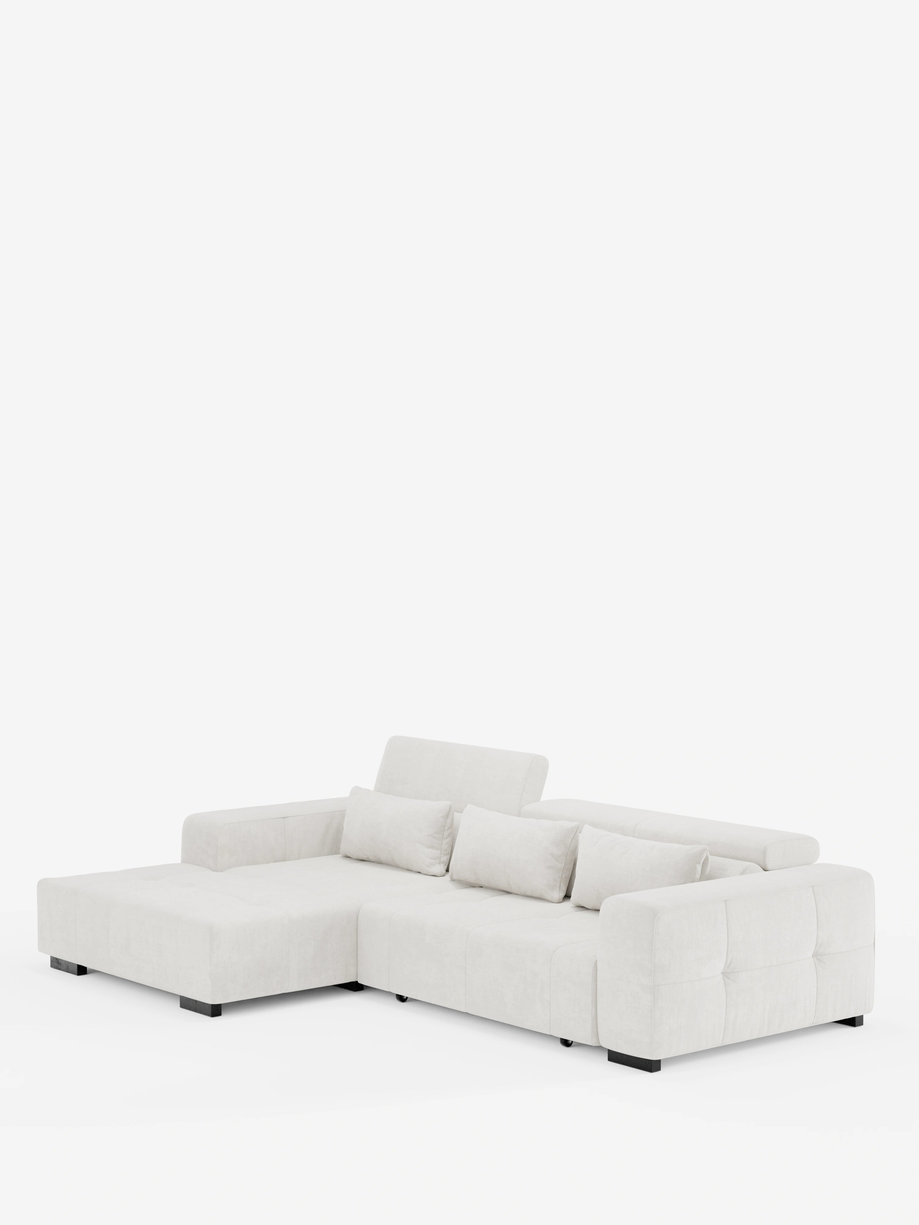 Il divano angolare Monarch con penisola e funzione relax elettrica per l’allungamento delle sedute di Divani.Store è un moderno divano componibile a L rivestito in tessuto T31 beige chiaro, morbido e resistente alle macchie. È dotato di tre cuscini dello schienale, due braccioli, gambe basse nere a blocco e poggiatesta regolabili per il massimo comfort, il tutto su uno sfondo bianco.