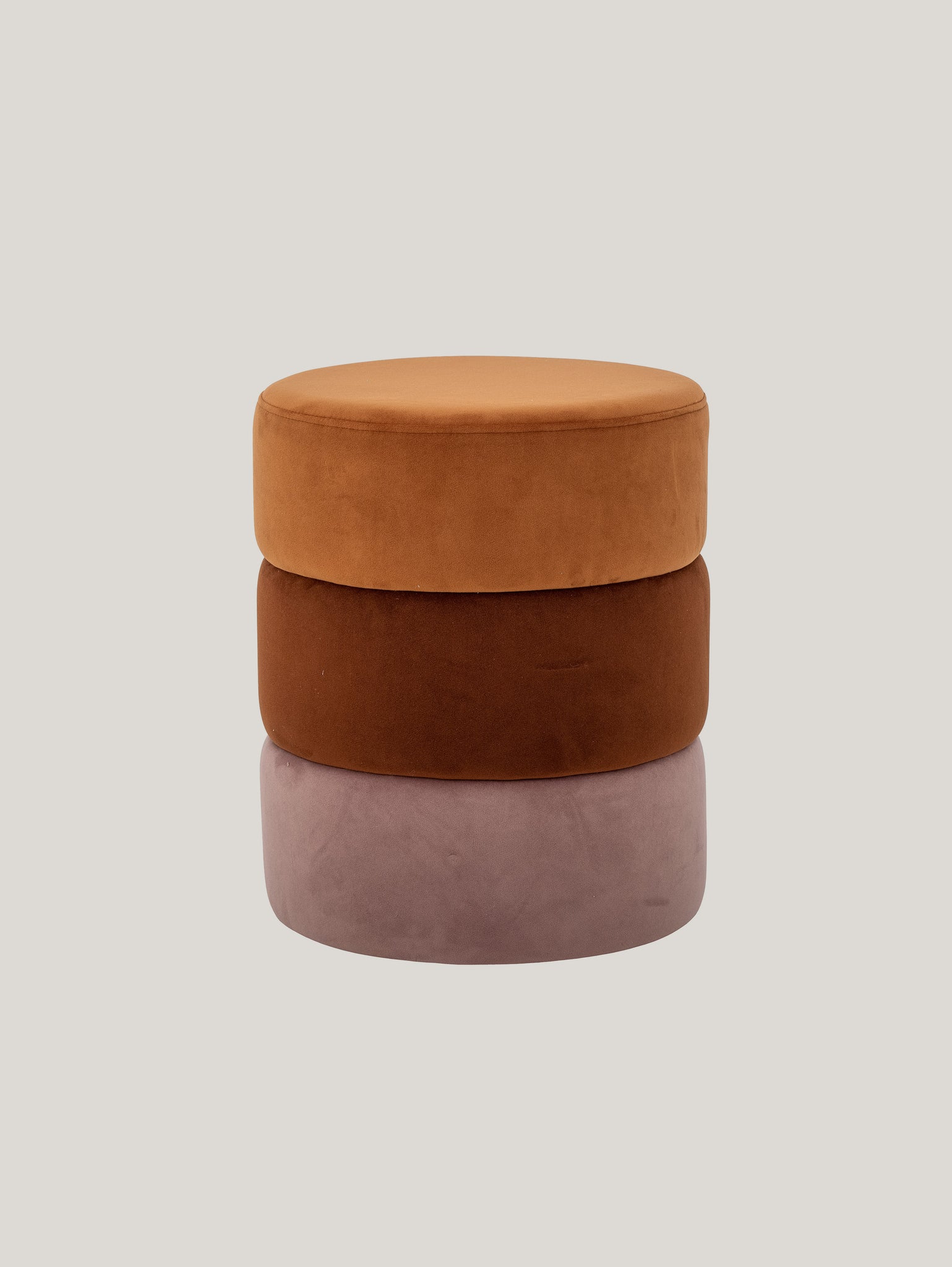 Su uno sfondo grigio chiaro, i toni invitanti dei cuscini impilati esaltano il fascino del pouf Bilbao tavolino multicolore cilindrico in velluto di Divani.Store. In cima è appoggiato un cuscino color cammello in velluto morbido, che si abbina magnificamente ai compagni ruggine e malva. Ogni pezzo rotondo e soffice contribuisce a un design esteticamente armonioso.