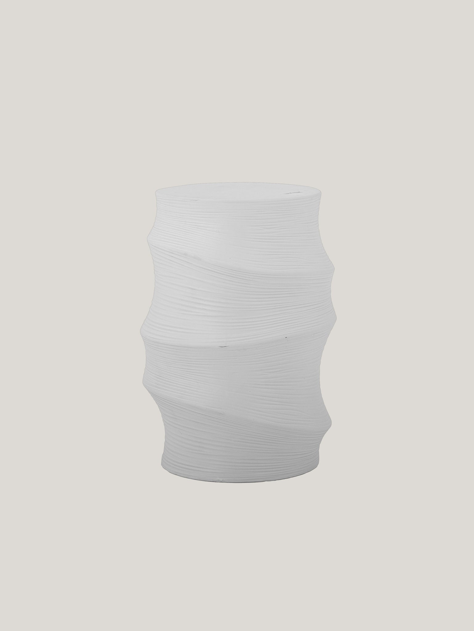 Ecco Volise tavolino scultoreo cilindrico in gres stoneware bianco di Divani.Store, un pezzo bianco e moderno realizzato in gres stoneware. Presenta un motivo a spirale strutturato e una forma a clessidra elegante su una base grigio chiaro. Il design cilindrico presenta curve morbide e fluide che creano un aspetto scultoreo dinamico e impressionante.