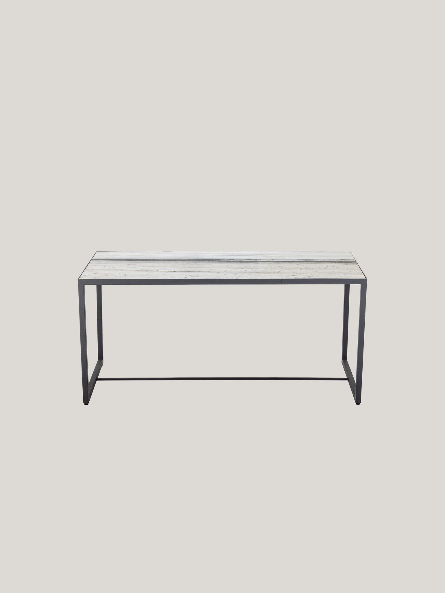 Su uno sfondo verde pallido si trova l'Ines tavolino rettangolare di Divani.Store, con piano in marmo bianco venato e cornice antracite. Questo pezzo vanta un design elegante e moderno con una forma rettangolare aperta sui lati che incarna un'estetica minimalista.