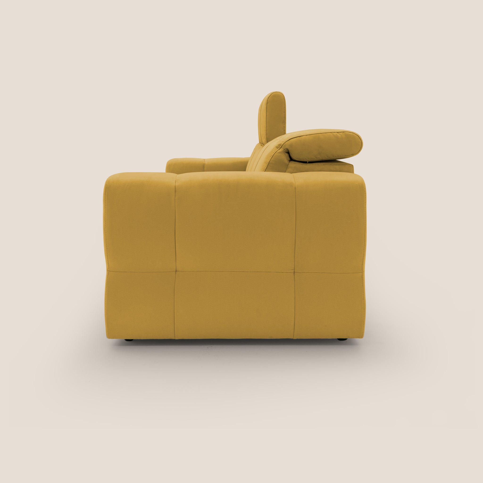 Il Divano 3 posti Kronos di Divani.Store, presentato in una tonalità di giallo acceso, spicca su uno sfondo beige chiaro. Questo divano contemporaneo presenta un design squadrato con trapuntatura quadrata e cuscini spessi. Il suo poggiatesta regolabile e il pratico rivestimento in morbida microfibra impermeabile assicurano sia stile che funzionalità.