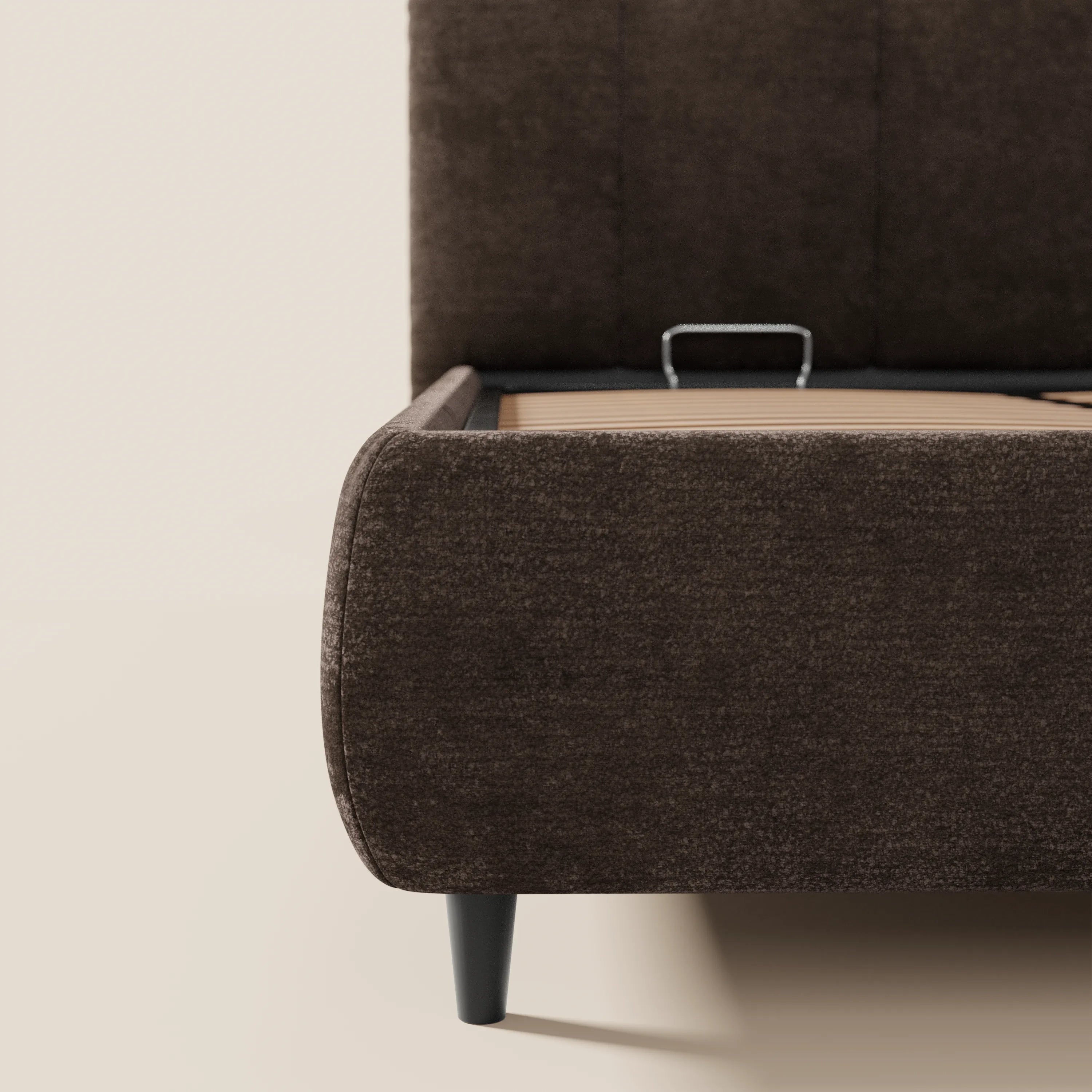 Un primo piano del letto imbottito ARKAM di Letti.store, realizzato in tessuto certificato Oeko-Tex® e caratterizzato da uno stile shabby chic, con testiera a cuciture verticali, angoli arrotondati, pediera, sponde laterali, base contenitiva e supporto per materasso in metallo.