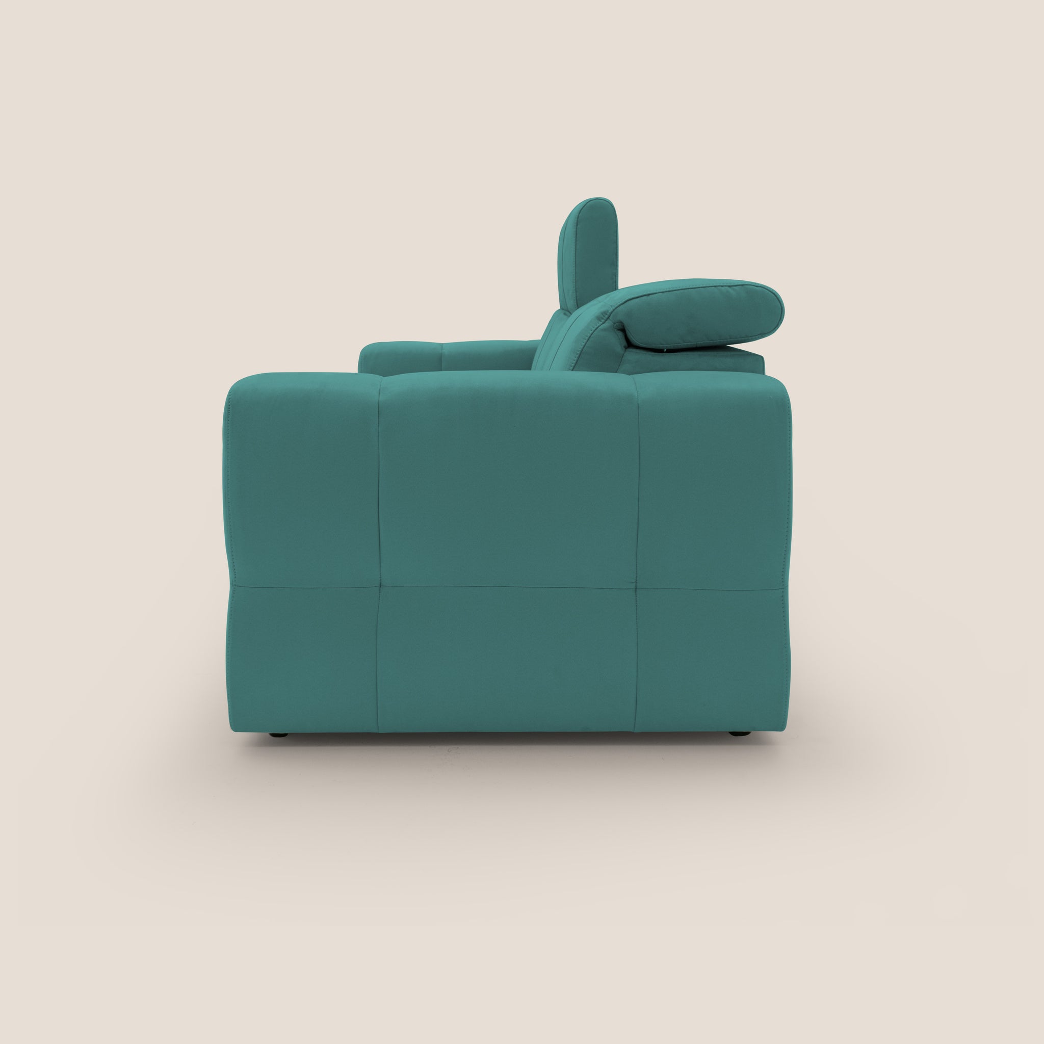 Vista laterale del Divano con pouf estraibile Kronos di Divani.Store, in moderno verde acqua su sfondo beige. Questo divano presenta cuscini morbidi, un poggiatesta regolabile e un design a blocchi che sottolinea il design contemporaneo moderno e mette in mostra lo squisito artigianato italiano.