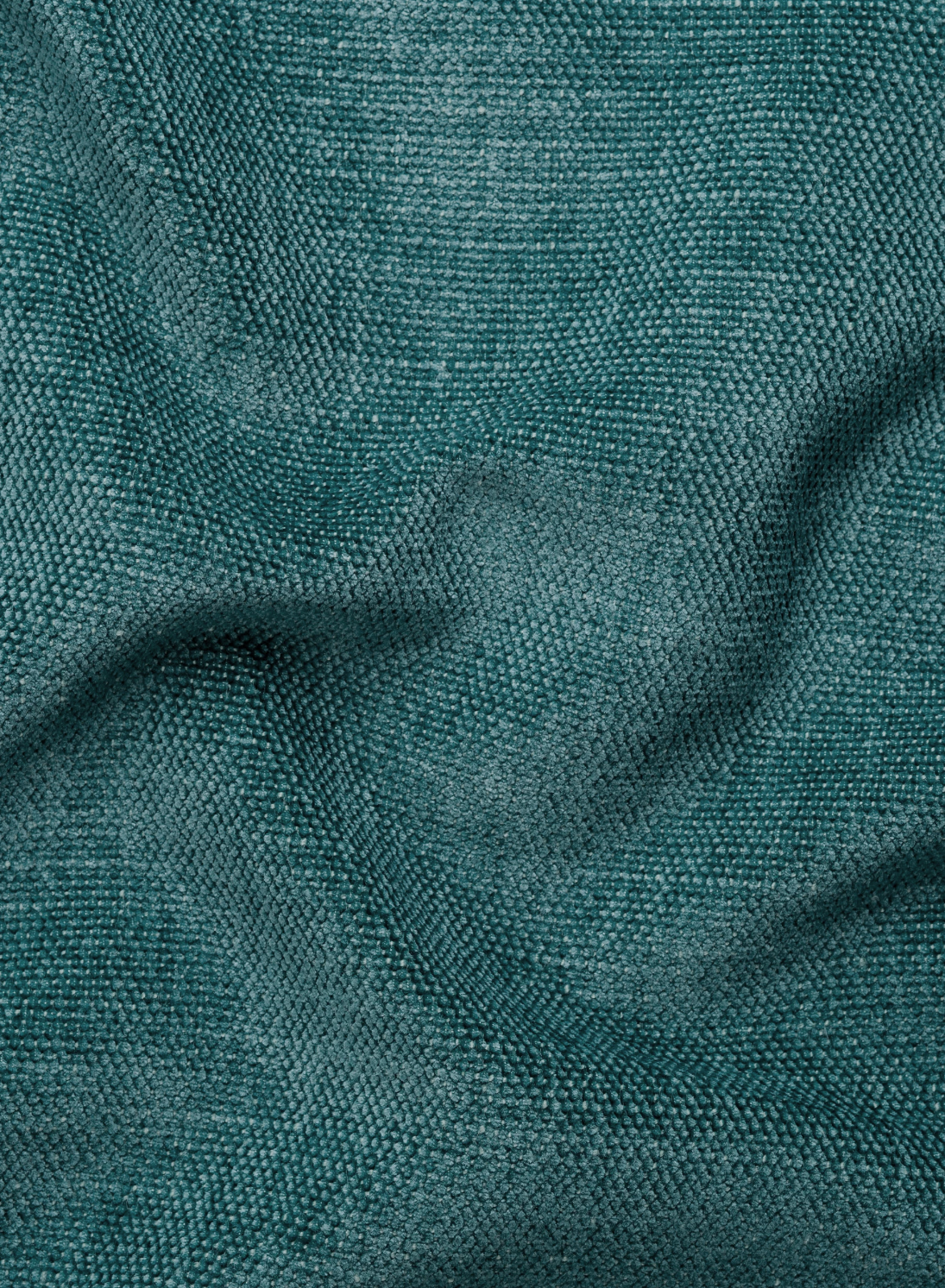 Primo piano su un tessuto color verde acqua dalla superficie intrecciata e ruvida, con morbide pieghe naturali, che caratterizza gli schienali traslanti di un divano a 3 posti Ischia con pouf estraibile e schienali traslanti in tessuto misto lino lavabile.