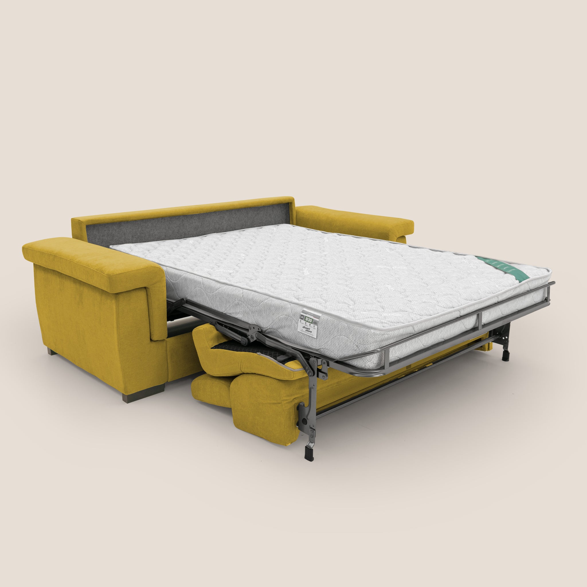 Un divano letto Bjorn giallo senape di Divani.Store è completamente esteso in posizione letto, con ampi braccioli e un materasso bianco visibile con motivo trapuntato. Lo sfondo beige chiaro semplice accentua il design moderno e il comfort superiore del divano letto, riflettendo accenni di artigianato italiano.