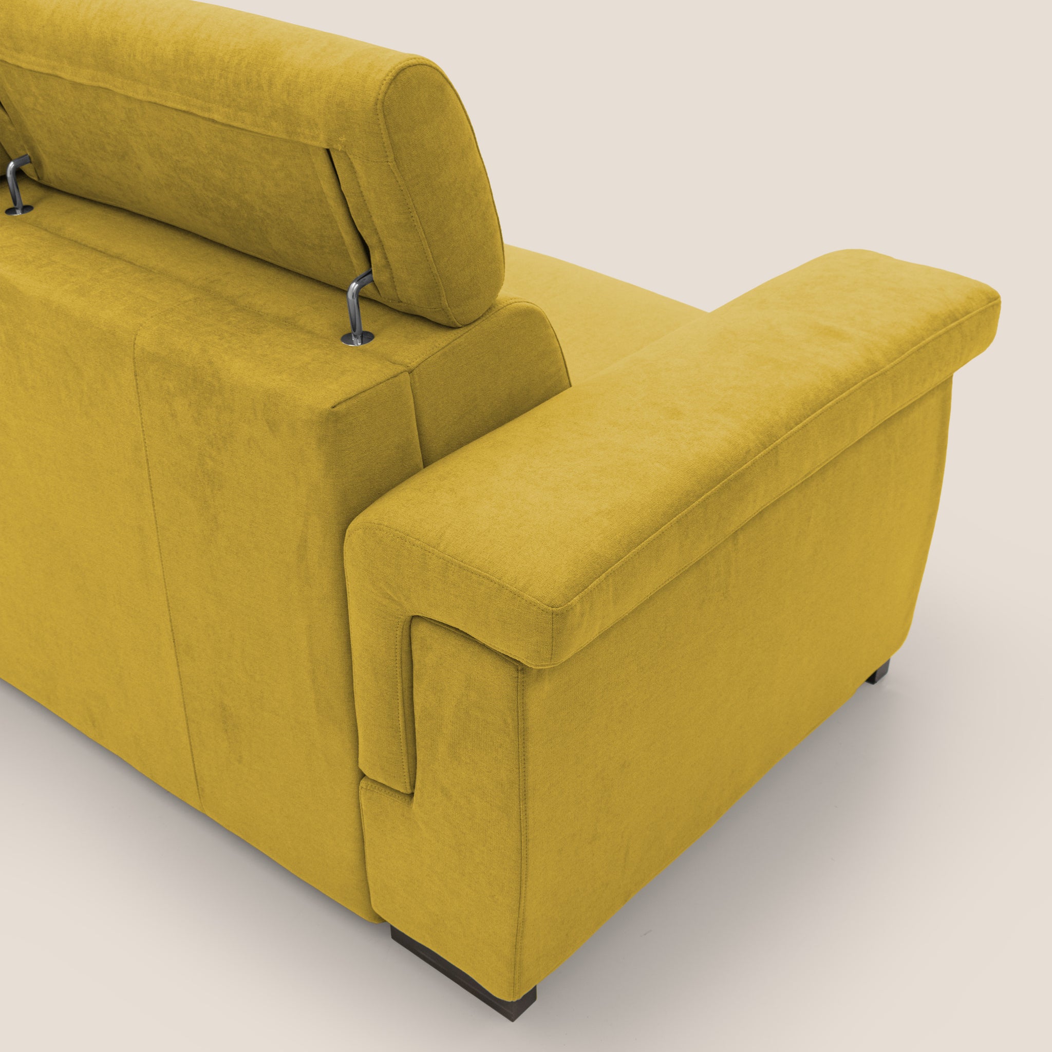 Un divano letto Bjorn in velluto giallo di Divani.Store, con poggiatesta regolabili, è mostrato di lato e sul retro, offrendo un comfort superiore. Vanta braccioli spessi e imbottiti e un design contemporaneo. Il morbido tessuto impermeabile T02 GIALLO completa i suoi piedini piatti e scuri su uno sfondo bianco sporco neutro.