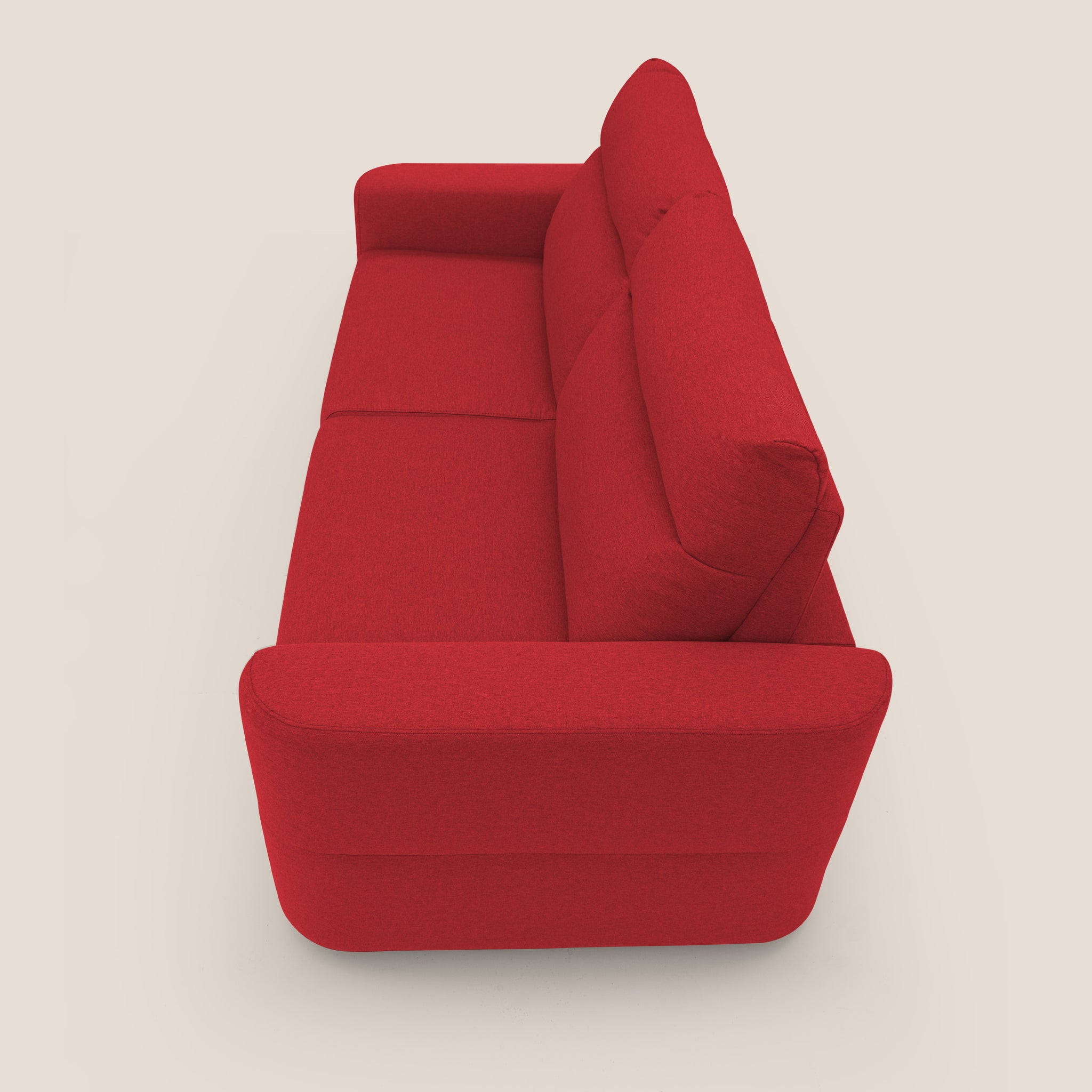 Un divano letto Cupido Divano letto rosso a tre posti di Divani.Store, con cuscini e braccioli morbidi, è esposto di lato su uno sfondo beige chiaro. Questo divano letto presenta un design moderno e minimalista con il suo rivestimento in tessuto liscio che ricorda il cotone e una silhouette elegante. Gli spessi cuscini dello schienale e della seduta assicurano un comfort avvolgente.