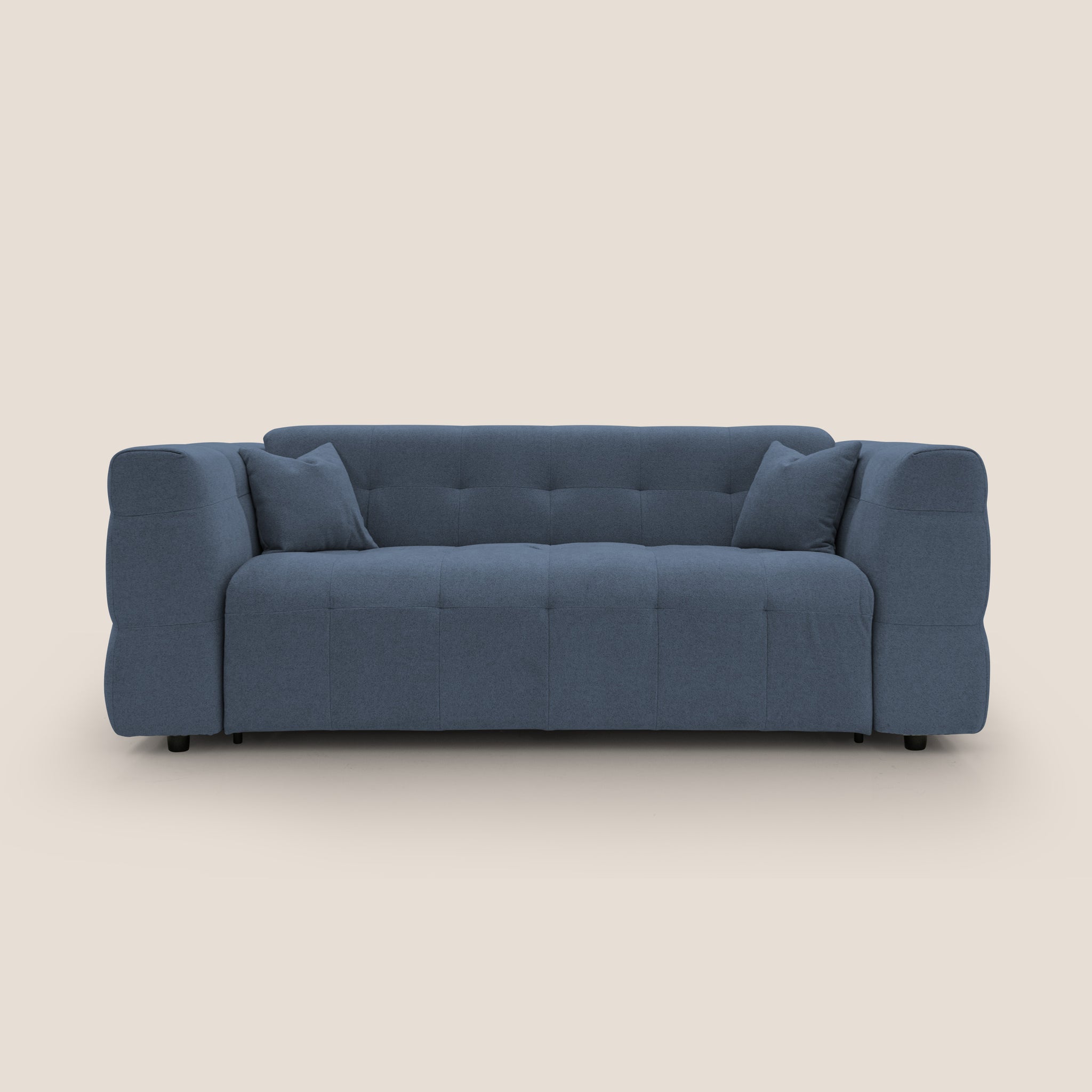 Il Tender Divano letto matrimoniale con materasso h18 cm in tessuto bouclet impermeabile T07 di Divani.Store è un divano letto blu scuro morbido e moderno con un design capitonné e braccioli spessi e arrotondati. Include due cuscini abbinati ed è posizionato su uno sfondo beige semplice. Questo design italiano fonde comfort e stile, con un profilo basso e piccole gambe nere.