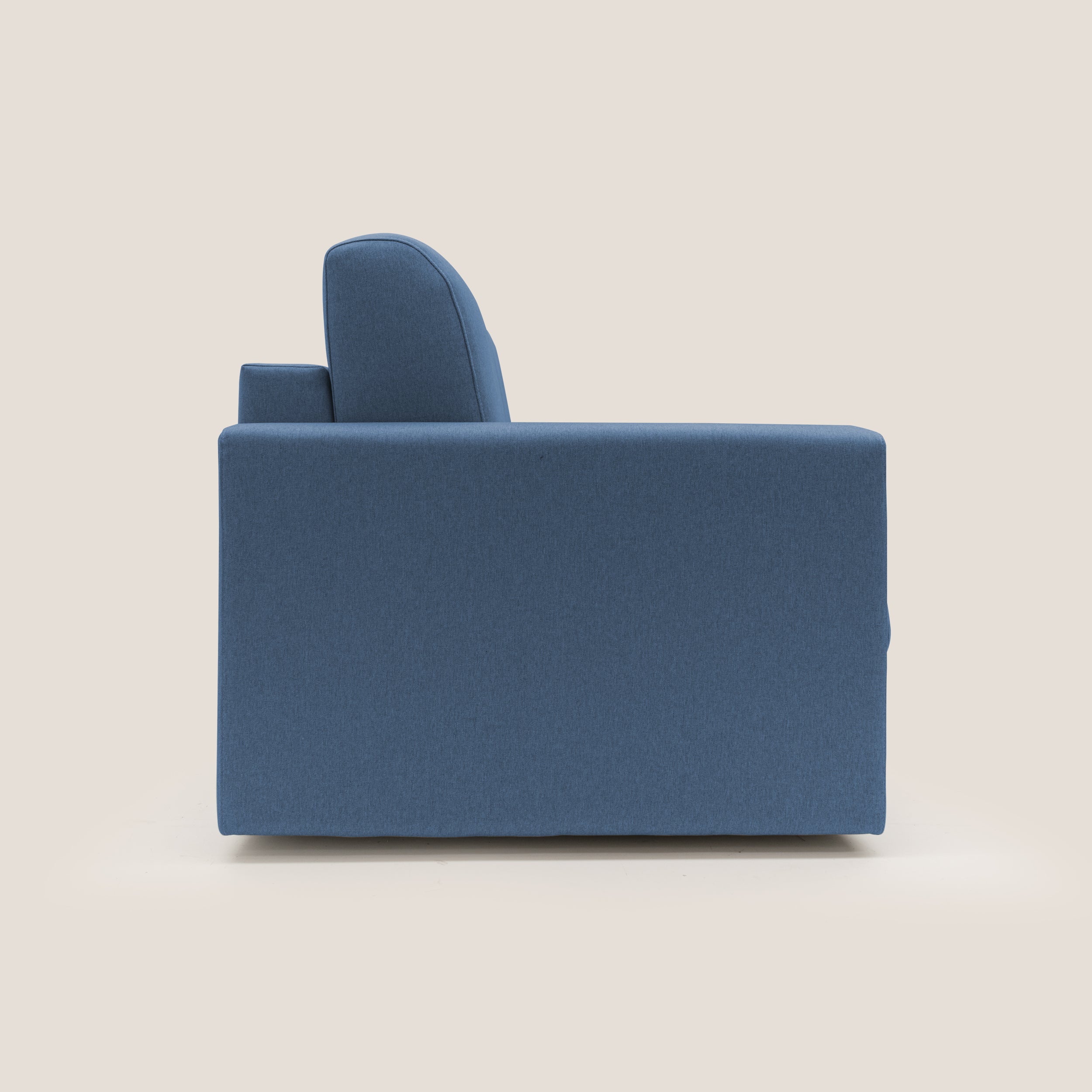 Il Chris Divano letto 206 cm di Divani.Store, rivestito in tessuto impermeabile T13 blu, è presentato lateralmente su uno sfondo beige chiaro. La sua forma squadrata e gli ampi braccioli evocano l'aspetto di un moderno divano trasformabile.