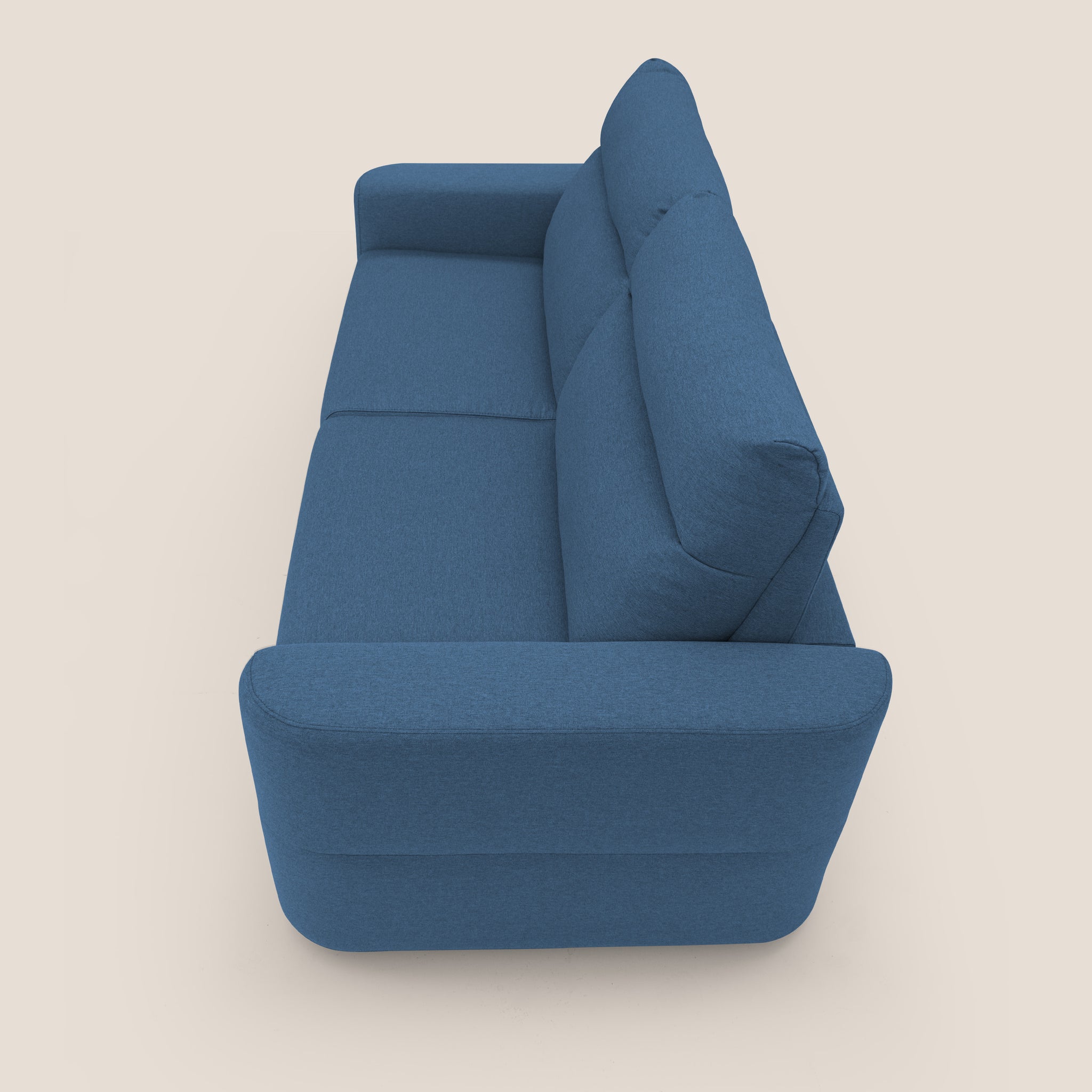 Vista dall'alto del Divano letto Cupido di Divani.Store, che mostra un design moderno con tessuto impermeabile blu che ricorda il cotone e due grandi cuscini. I suoi braccioli arrotondati enfatizzano il comfort, mentre il suo design elegante risalta su uno sfondo beige chiaro e semplice, evidenziandone lo stile minimalista e il colore vivace. Realizzato in Italia per una qualità eccezionale.