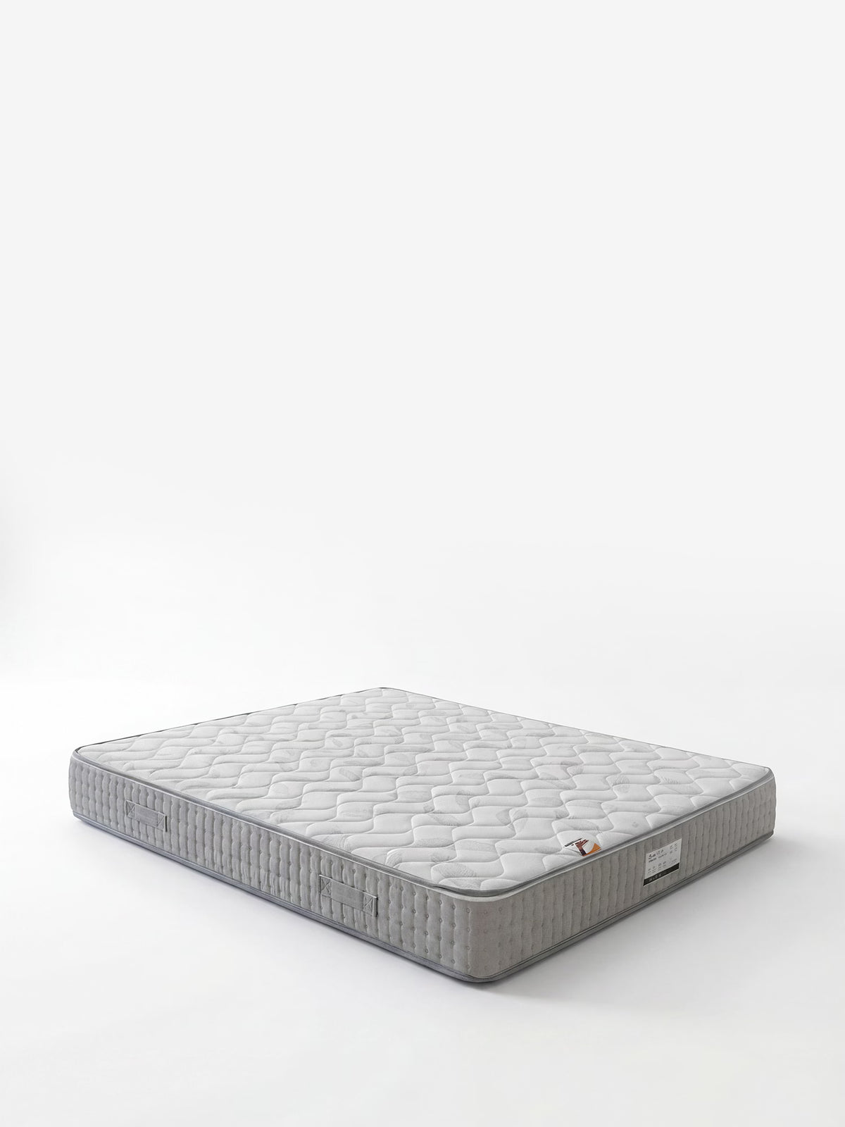 Un materasso AERION grigio chiaro – Materasso ortopedico in Memory & Aquapur per un riposo leggero come l’aria di Divani.Store, caratterizzato da un motivo esagonale trapuntato e da una piccola etichetta del marchio sul bordo inferiore, è raffigurato su uno sfondo bianco. Non sono visibili né la struttura del letto né altri oggetti. Il materasso appare pulito, piatto e nuovo.