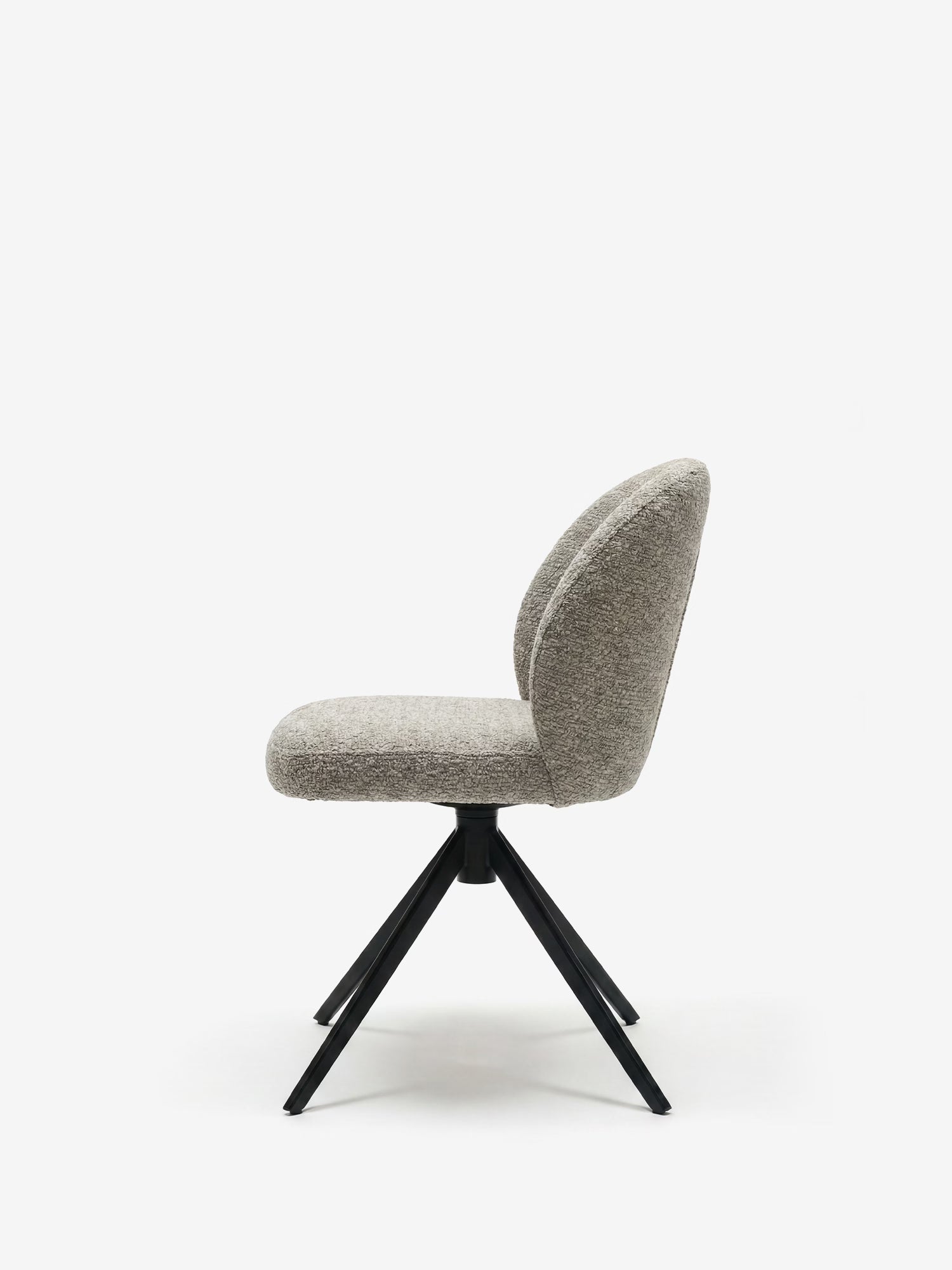 La sedia imbottita Alba di Divani.Store è caratterizzata da un tessuto effetto cotone certificato OEKO-TEX® in grigio, da una seduta e uno schienale imbottiti dalle forme arrotondate e da quattro gambe angolari in metallo nero, il tutto su uno sfondo bianco a tinta unita.
