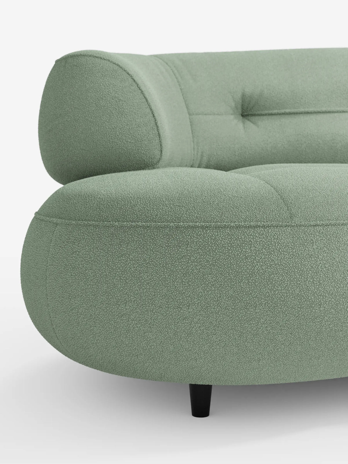 Un primo piano del divano Curvato a fagiolo “Croissant” a 3 posti, color verde salvia, con schienali traslanti, rivestito in morbido tessuto effetto cotone smacchiabile T33, caratterizzato da bordi arrotondati, schienale trapuntato con bottoni e gambe corte e scure su sfondo bianco.