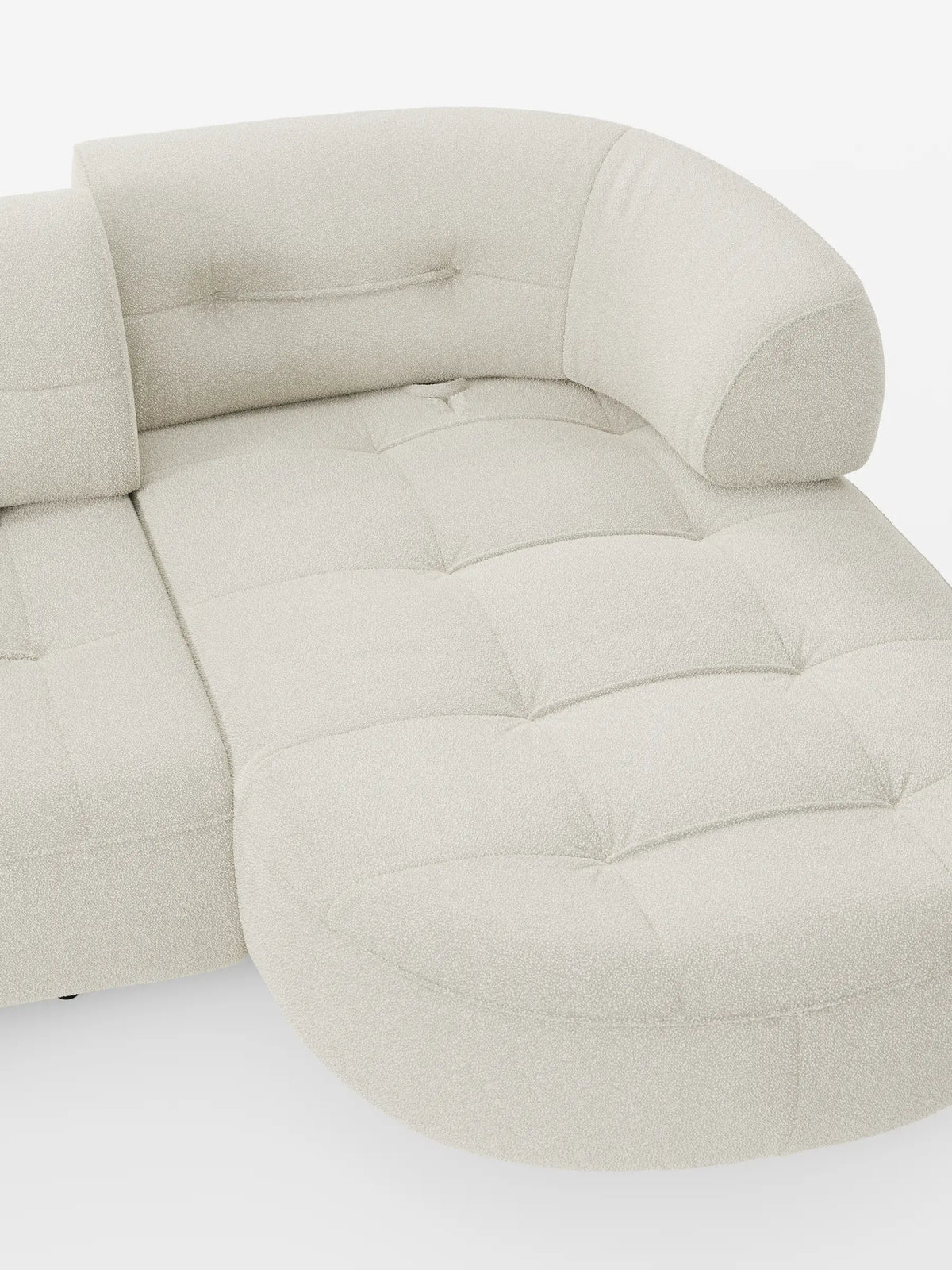 Un divano angolare Croissant color crema, dalla forma a fagiolo e con schienali scorrevoli, rivestito in morbido tessuto effetto cotone lavabile T33, caratterizzato da un tessuto trapuntato e testurizzato e da un design arrotondato e moderno su sfondo bianco.