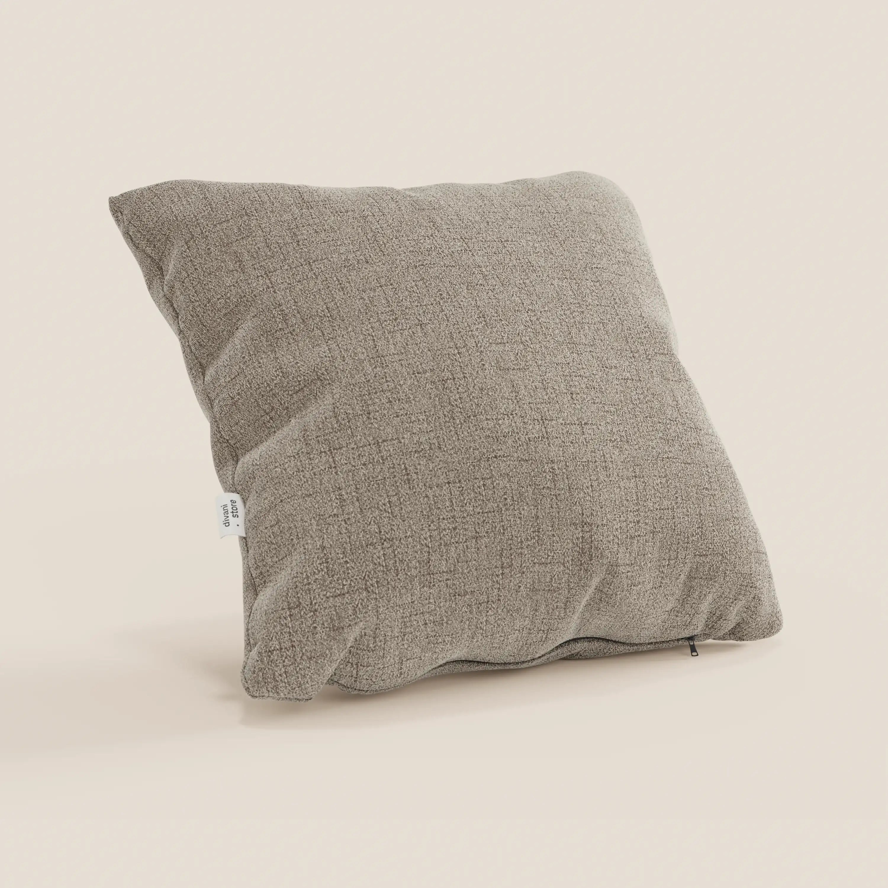 Il cuscino Felis beige di Divani.Store, quadrato e strutturato, realizzato in morbido tessuto idrorepellente T03, è caratterizzato da una piccola etichetta bianca sulla cucitura sinistra ed è posizionato in verticale su uno sfondo bianco sporco per un aspetto felpato e protettivo.