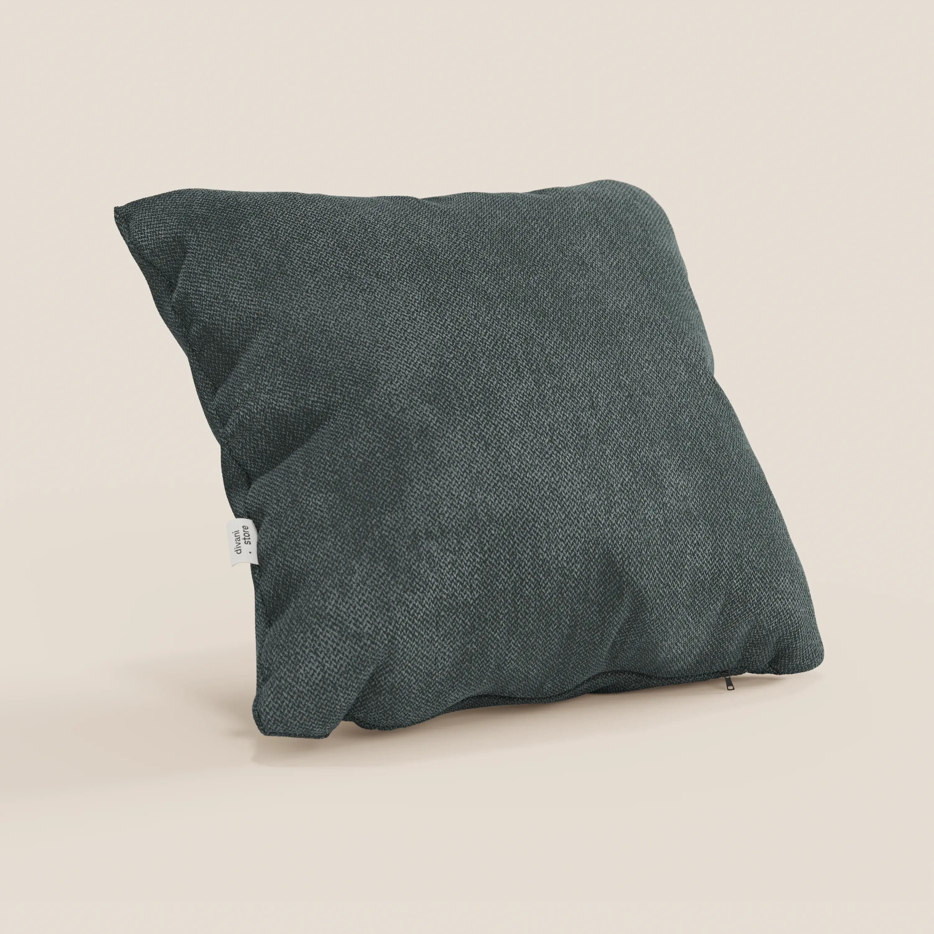 Il cuscino A Sogno di Divani.Store in tessuto morbido SMACCHIABILE T05 verde, con etichetta bianca laterale, è appoggiato su sfondo beige chiaro. L'aspetto leggermente stropicciato lo rende perfetto tra i tuoi cuscini eleganti per divano.