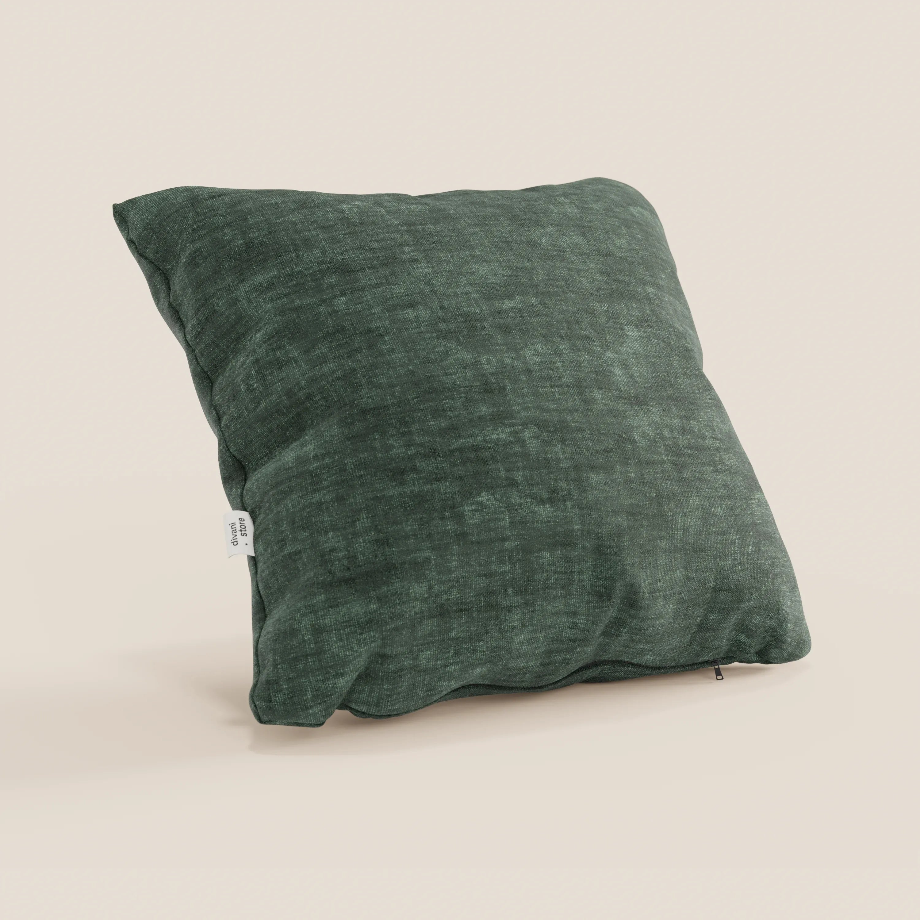 Un cuscino quadrato Sofia verde scuro di Divani.Store, in morbido velluto nuvolato antimacchia e impermeabile (Easy Clean T35), si trova in posizione verticale su uno sfondo beige chiaro. Sono visibili anche una piccola etichetta laterale bianca e una cerniera inferiore.