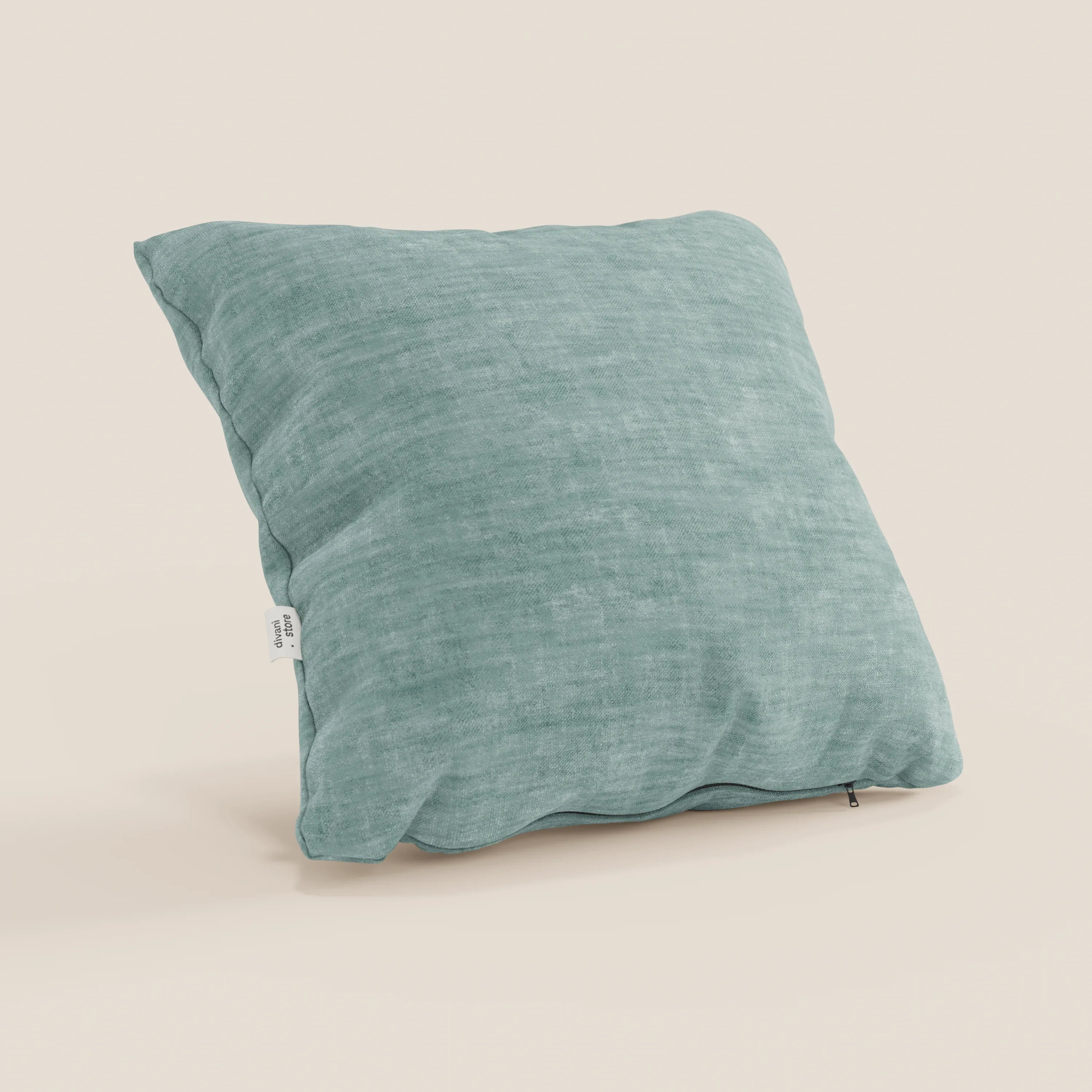 Il cuscino Sofia di Divani.Store, in velluto Easy Clean T35 lavabile e impermeabile, è leggermente inclinato su uno sfondo beige chiaro, con una piccola etichetta bianca e una discreta cerniera sul bordo inferiore.