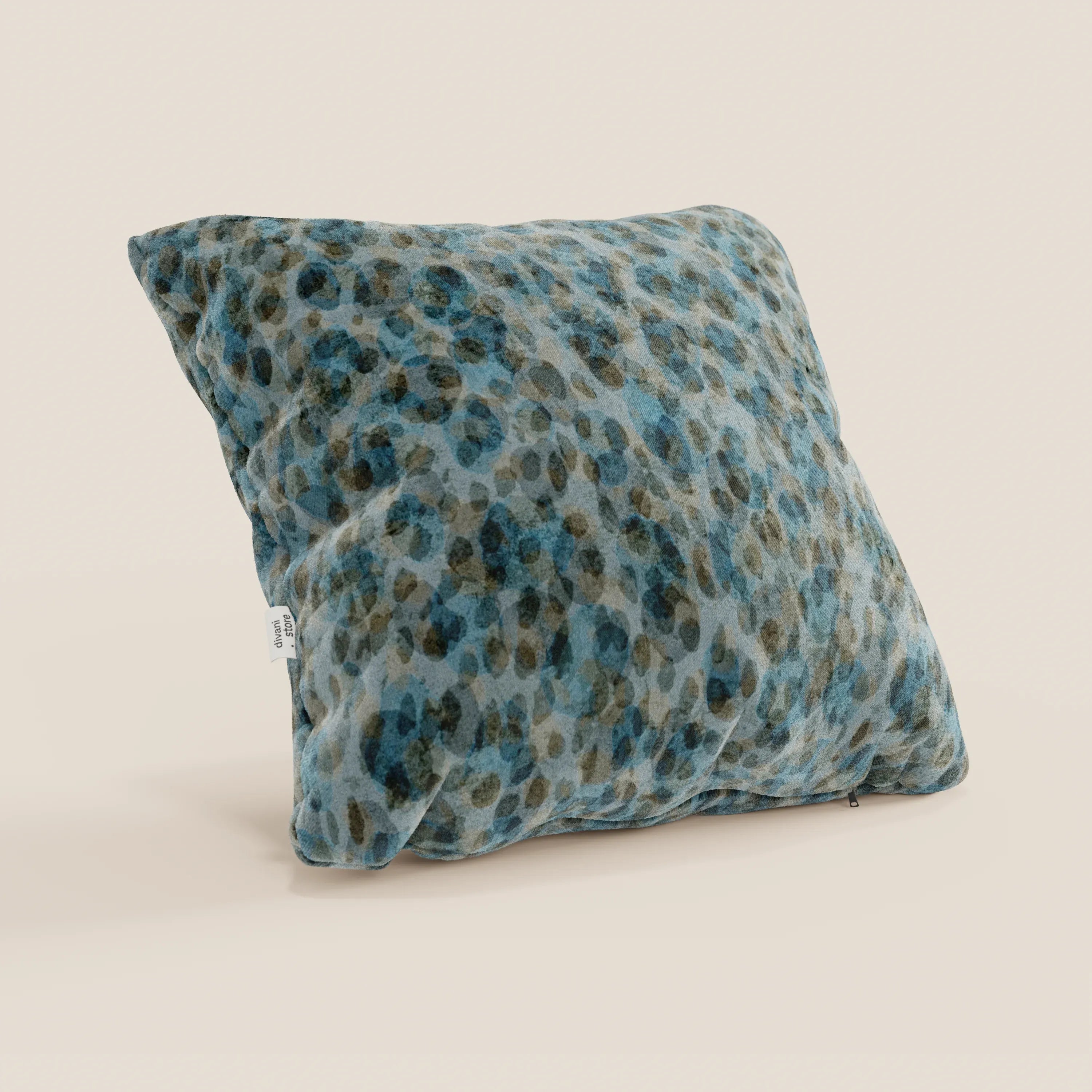 I cuscini Brush di Divani.Store, 45x45 cm, sono caratterizzati da un velluto blu impermeabile, felpato e con etichetta laterale visibile, su sfondo beige chiaro.