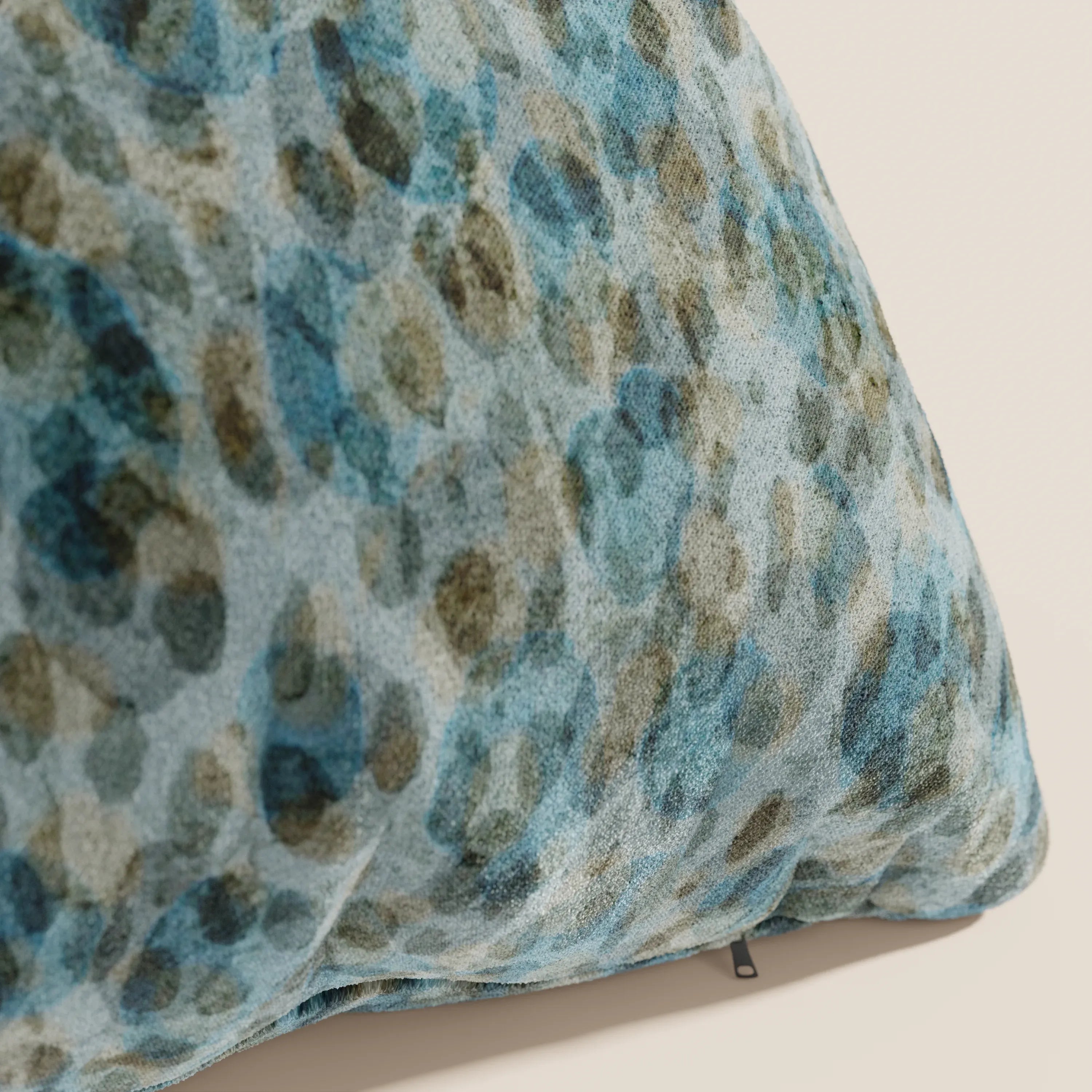 Primo piano del cuscino Brush 45x45 cm di Divani.Store, realizzato in velluto azzurro impermeabile, caratterizzato da un morbido rivestimento e da un motivo astratto blu e oliva, perfetto per aggiungere un tocco organico a qualsiasi ambiente.