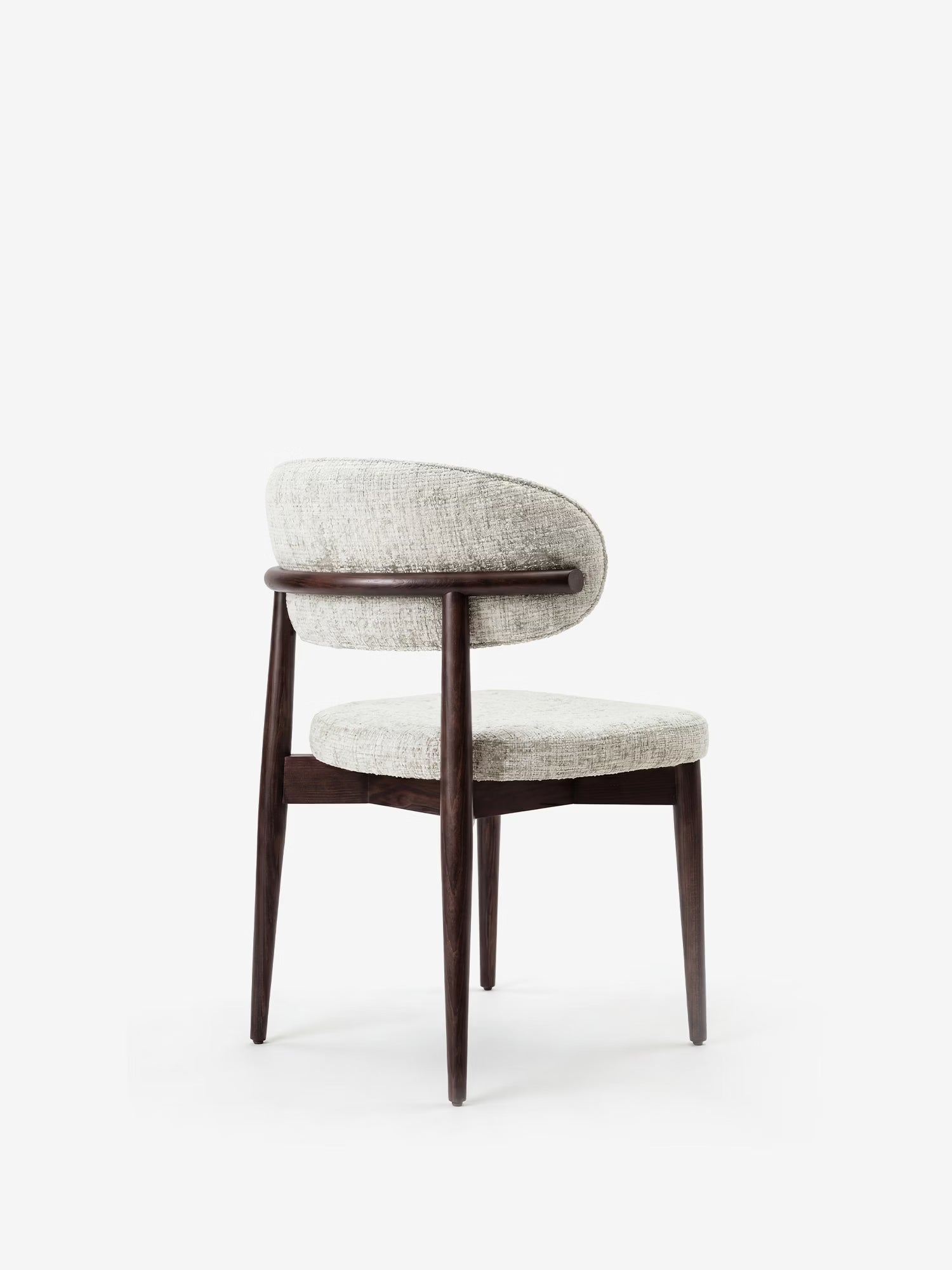 La sedia di design imbottita Dafne di Divani.Store presenta quattro gambe in legno massello wengé, una seduta circolare e uno schienale curvo rivestito in ciniglia grigio chiaro certificata OEKO-TEX®, che unisce eleganza e stile contemporaneo.