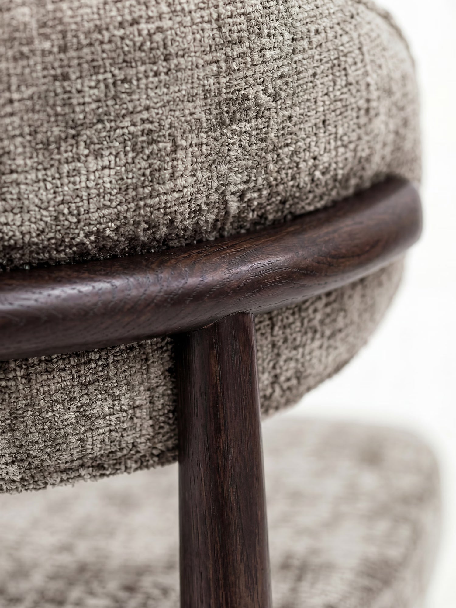 Primo piano del modello Dafne Sedia di Divani.Store, realizzato in legno massello wengé e rivestito in tessuto ciniglia certificato OEKO-TEX®, che mette in risalto i cuscini grigi chiari con trama in rilievo e la struttura in legno scuro dalle curve eleganti e dai dettagli artigianali.
