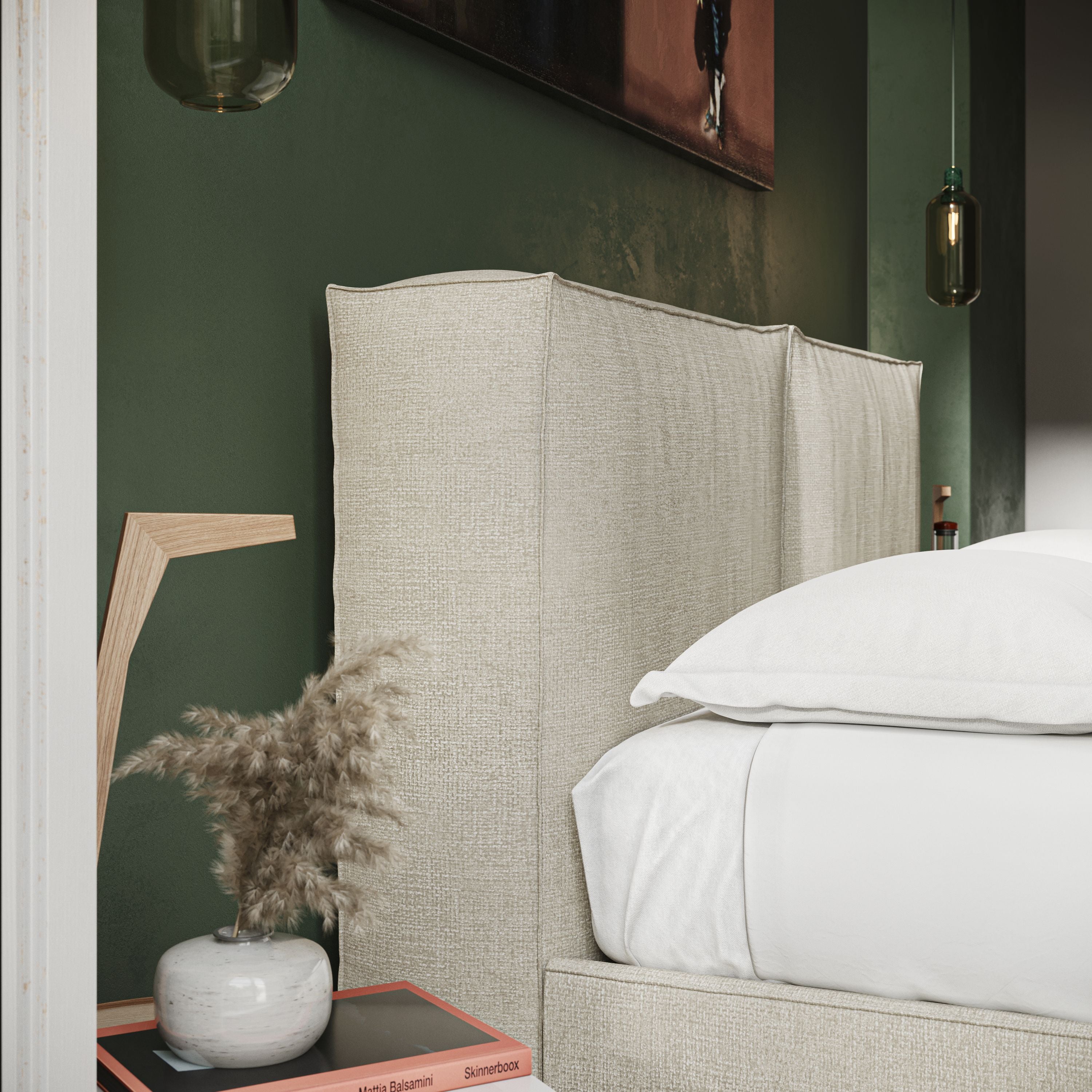 L'Isotta letto imbottito completamente sfoderabile in morbido tessuto impermeabile T10 panna di Letti.store è caratterizzato da una biancheria da letto bianca e da una parete verde scuro, con un tavolo che contiene libri, un vaso con erba secca e una lampada in legno.