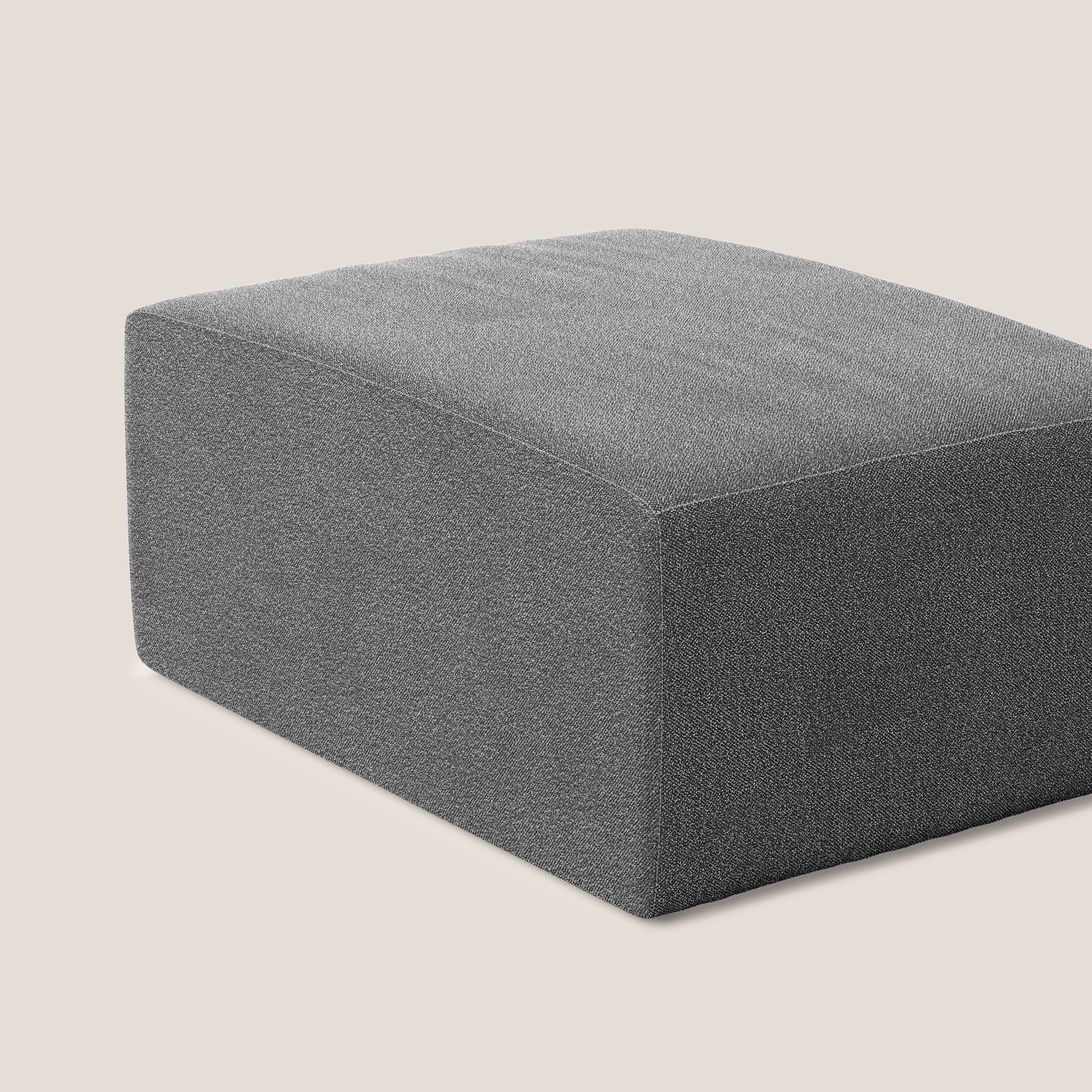 Un pouf minimalista in tessuto grigio, in particolare il pouf Nettuno elemento 70x100 cm in morbido bouclè T07 ANTRACITE di Divani.Store, è incentrato su uno sfondo semplice, chiaro, bianco sporco. Il pouf presenta linee pulite e un design semplice, realizzato in morbido bouclè, che lo rende adatto a un arredamento moderno.