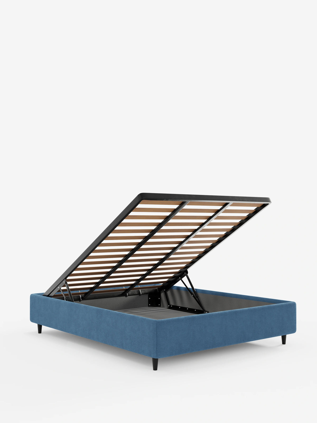 Il letto sommier imbottito ERON con vano contenitore in tessuto impermeabile certificato Oeko-Tex di colore blu, raffigurato con la rete a doghe sollevata per mostrare lo spazio di stivaggio, poggia su quattro sottili gambe nere su uno sfondo bianco a tinta unita.