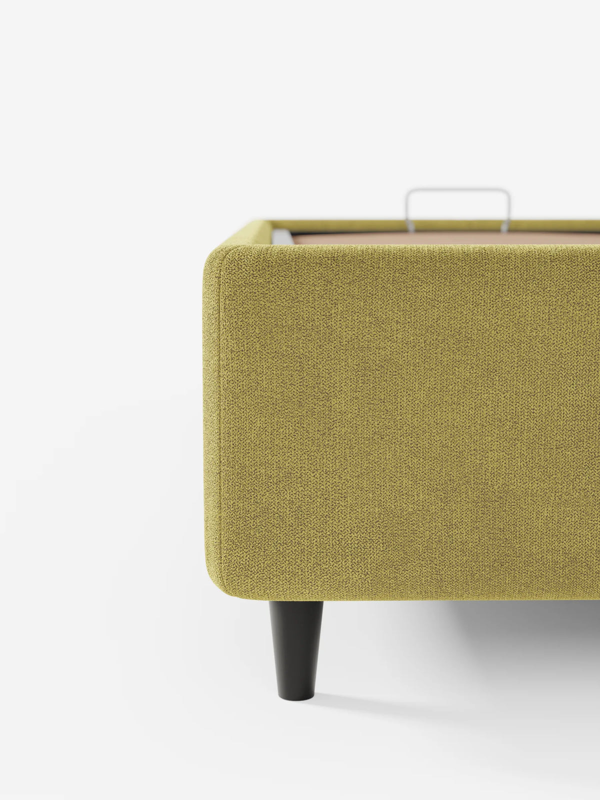 Un primo piano del letto sommier imbottito ERON con vano contenitore in tessuto impermeabile certificato Oeko-Tex color verde lime, che ne mette in risalto il tessuto a trama, le gambe corte e affusolate di colore scuro e una maniglia in metallo sul bordo interno della piattaforma sollevata.