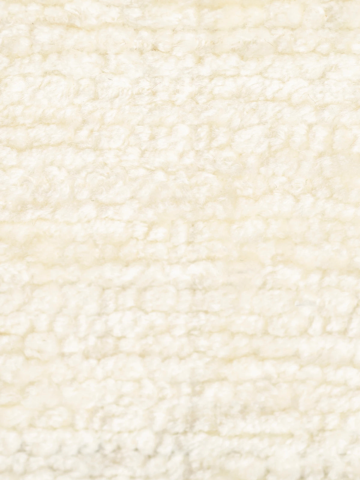Un primo piano di S02 ELITE, un tessuto materico strutturato e smacchiabile in ciniglia, di colore bianco sporco, con un vello bouclé morbido, denso e nodoso che crea una superficie accogliente e uniforme.