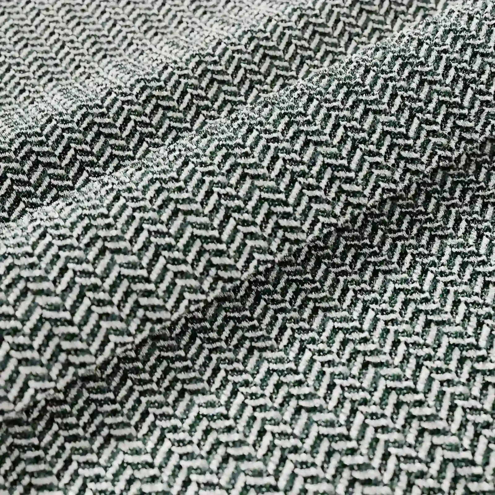 Primo piano del cuscino Sorrento 45x45 in lino di Divani.Store, che mette in risalto la trama a spina di pesce con fili verde scuro e bianchi: ideale per cuscini lavabili in lavatrice. L'elegante piega esalta il suo design geometrico e ricco di texture.