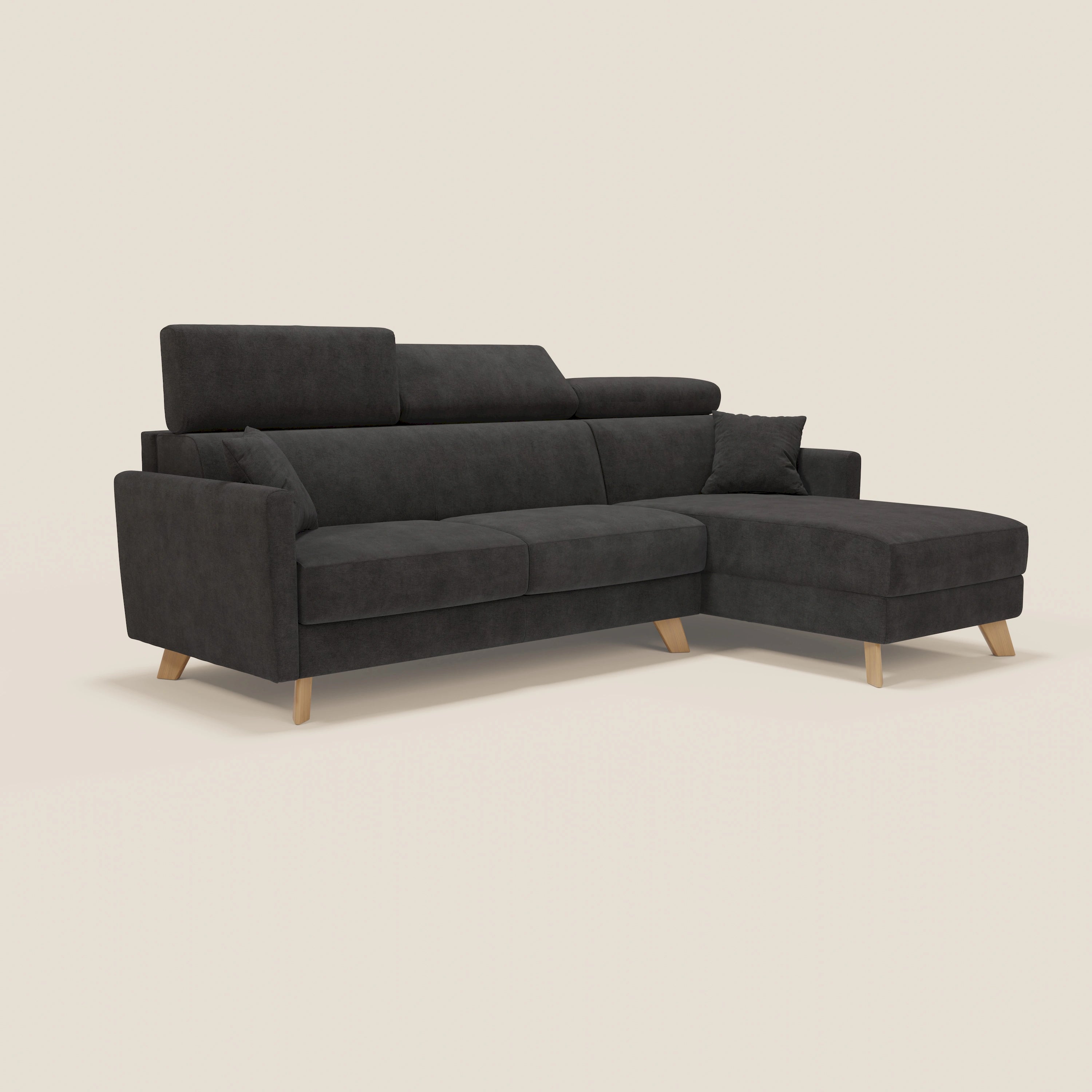 Il divano letto angolare Francy sfoderabile di Divani.Store in tessuto nero smacchiabile T17 ha penisola contenitore a destra, poggiatesta reclinabili e piedini in legno. Completo di cuscino coordinato, ideale per un look stile nordico su sfondo chiaro.