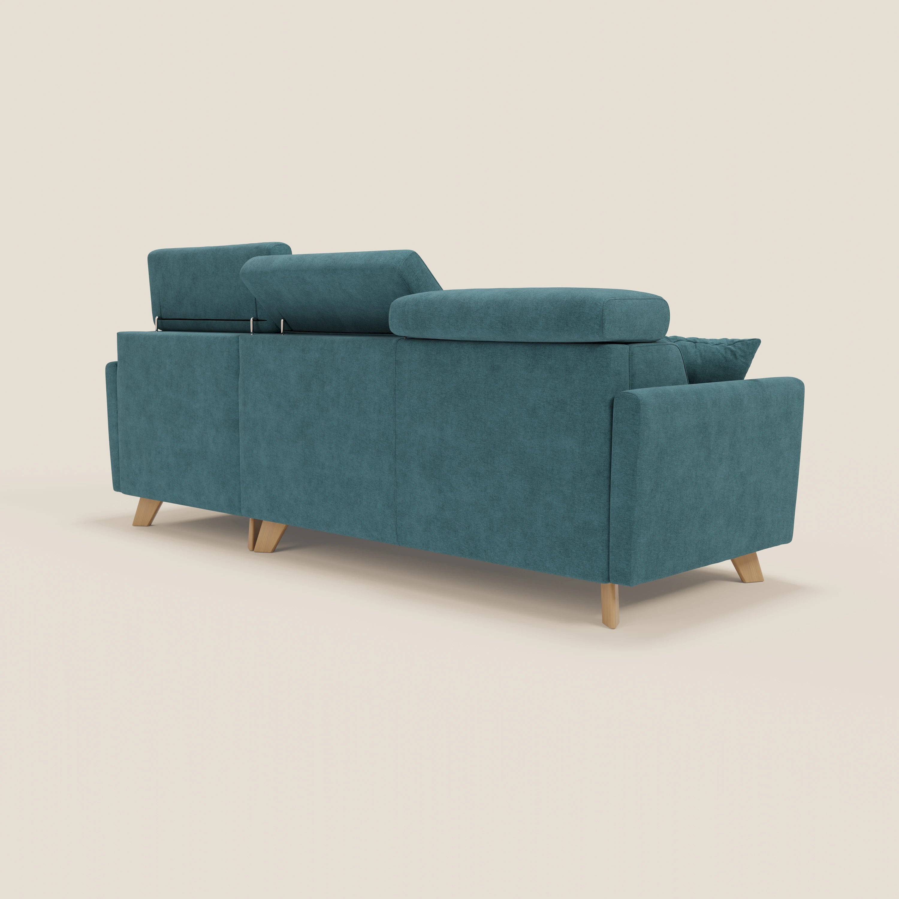 Il divano letto angolare sfoderabile Francy di Divani.Store, in tessuto smacchiabile T17 petrolio con poggiatesta reclinabile e chaise longue contenitore, è presentato dal retro su sfondo beige chiaro, con stile nordico e cuscino laterale destro.