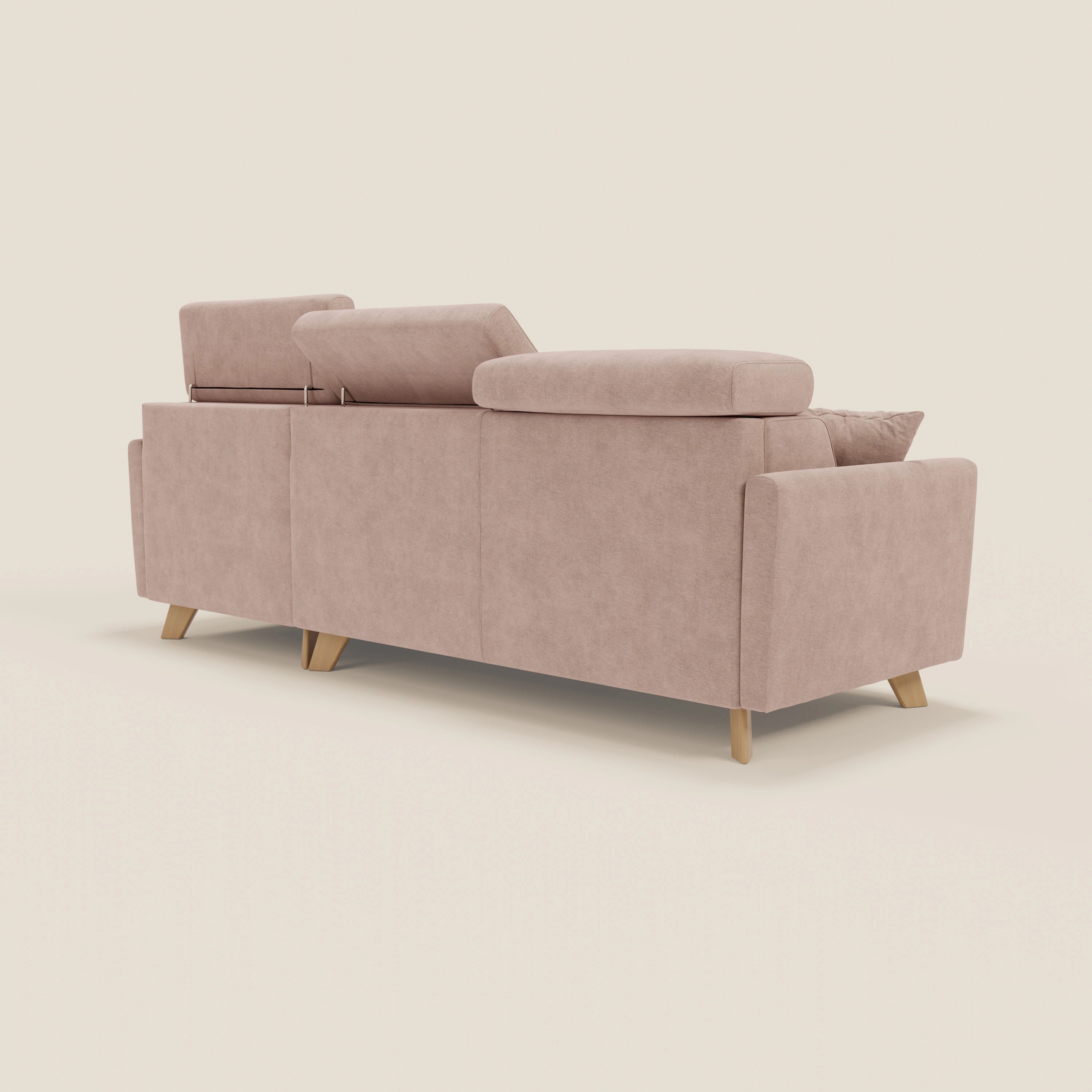 Il divano letto angolare sfoderabile Francy di Divani.Store, in tessuto antimacchia rosa T17, è dotato di una chaise longue e di poggiatesta regolabili; nella foto, lo schienale con la parte sinistra e centrale sollevata e la parte destra abbassata, su uno sfondo bianco sporco.