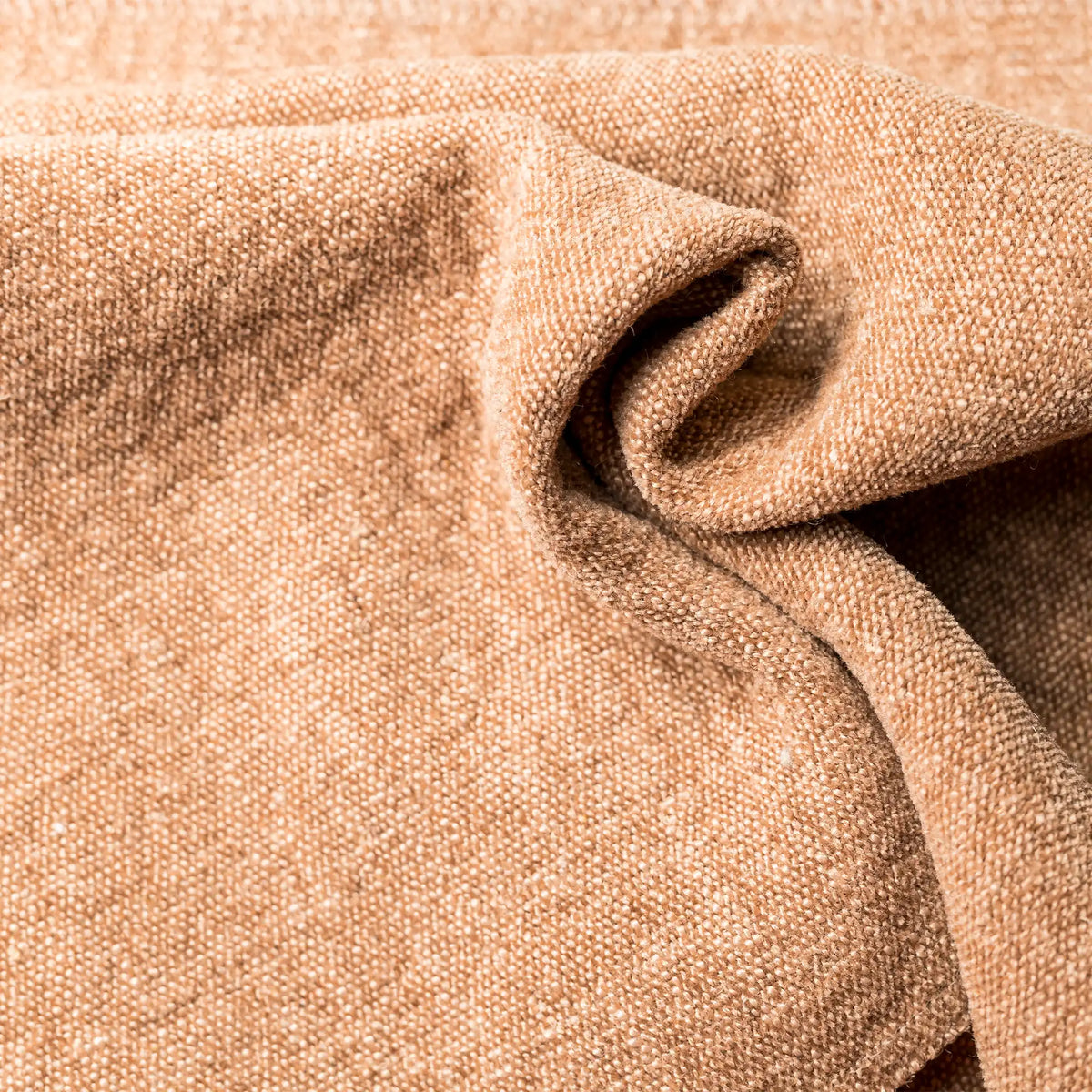 Primo piano della Personalizzazione color cuoio in tessuto T36 APOLLO, caratterizzato da una trama intrecciata a vista, drappeggiato in morbide pieghe con una delicata tonalità beige terrosa e ombre profonde all’interno delle pieghe.