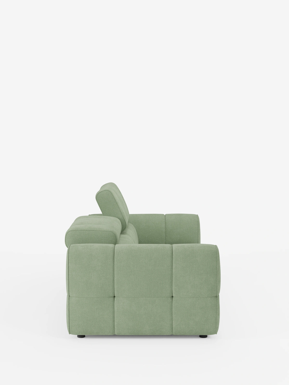 Vista laterale di un divano modulare Giotto a 3 posti color verde salvia, con poggiatesta reclinabili e funzione relax elettrica opzionale, rivestito in tessuto smacchiabile T23 su sfondo bianco; il modello presenta un design squadrato e trapuntato, con poggiatesta reclinabili e piedini bassi.