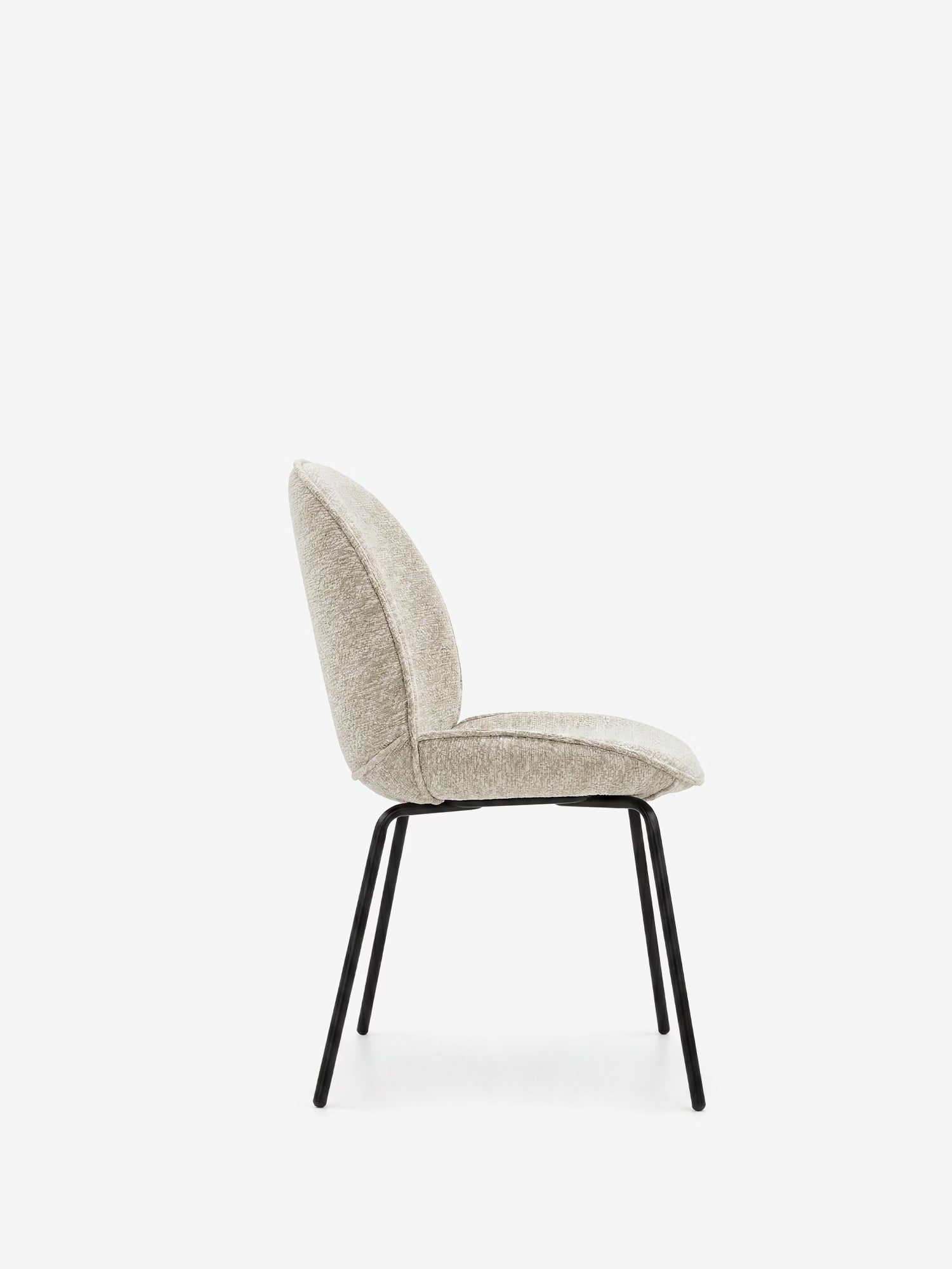 La sedia imbottita Iride di Divani.Store è raffigurata di profilo su uno sfondo bianco; presenta seduta e schienale in tessuto beige morbido al tatto dalle linee curve e sottili gambe in metallo nero, per un look moderno e minimalista.
