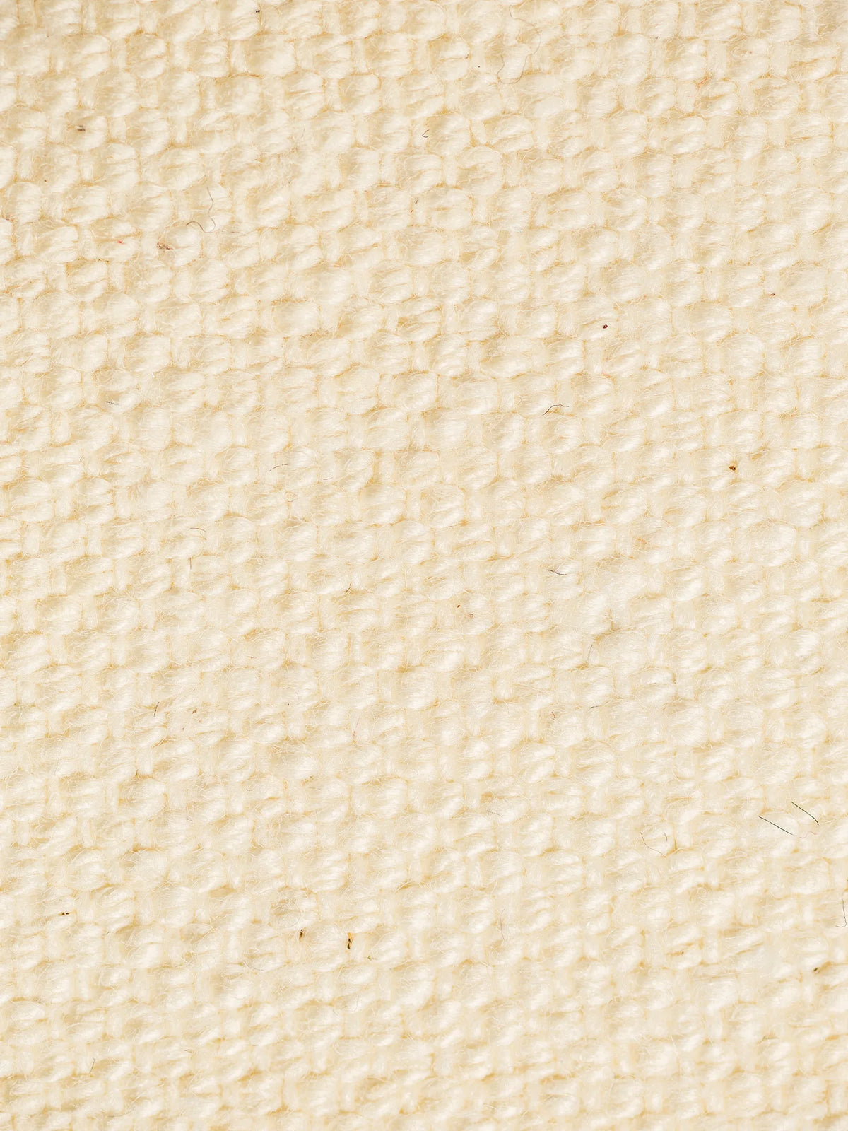 Un primo piano del tessuto S06 LINOSA, realizzato al 100% in cotone riciclato, caratterizzato da un motivo a intreccio a canestro di colore crema e di spessa trama, con fibre morbide simili alla canapa distribuite su tutta la superficie del tessuto in cotone riciclato.