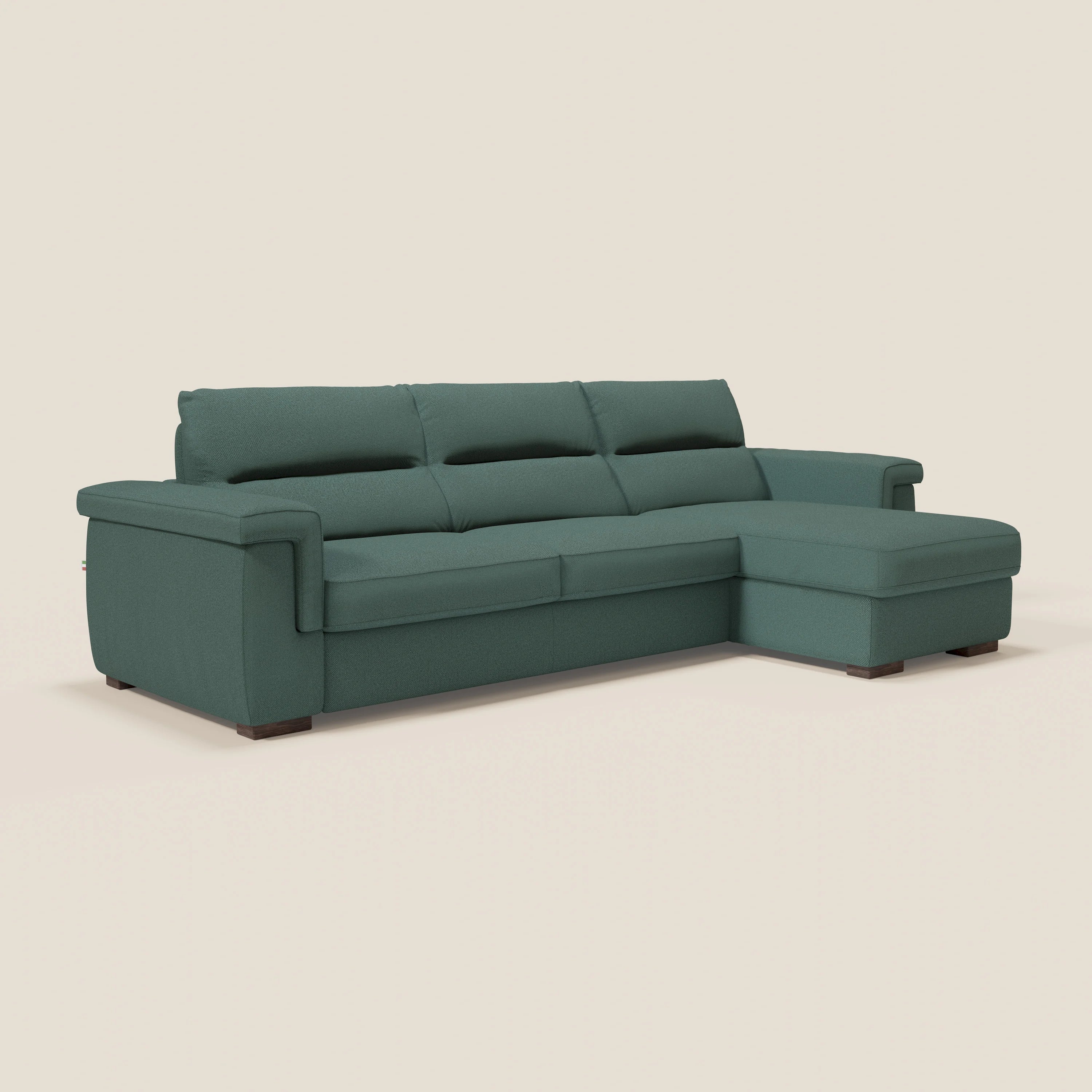 Il divano letto angolare Magnolia con penisola contenitore di Divani.Store è dotato di tre cuscini, chaise longue destra, schienali imbottiti, ampi braccioli, piedi bassi in legno scuro e materasso H18 cm in tessuto smacchiabile T05 verde.