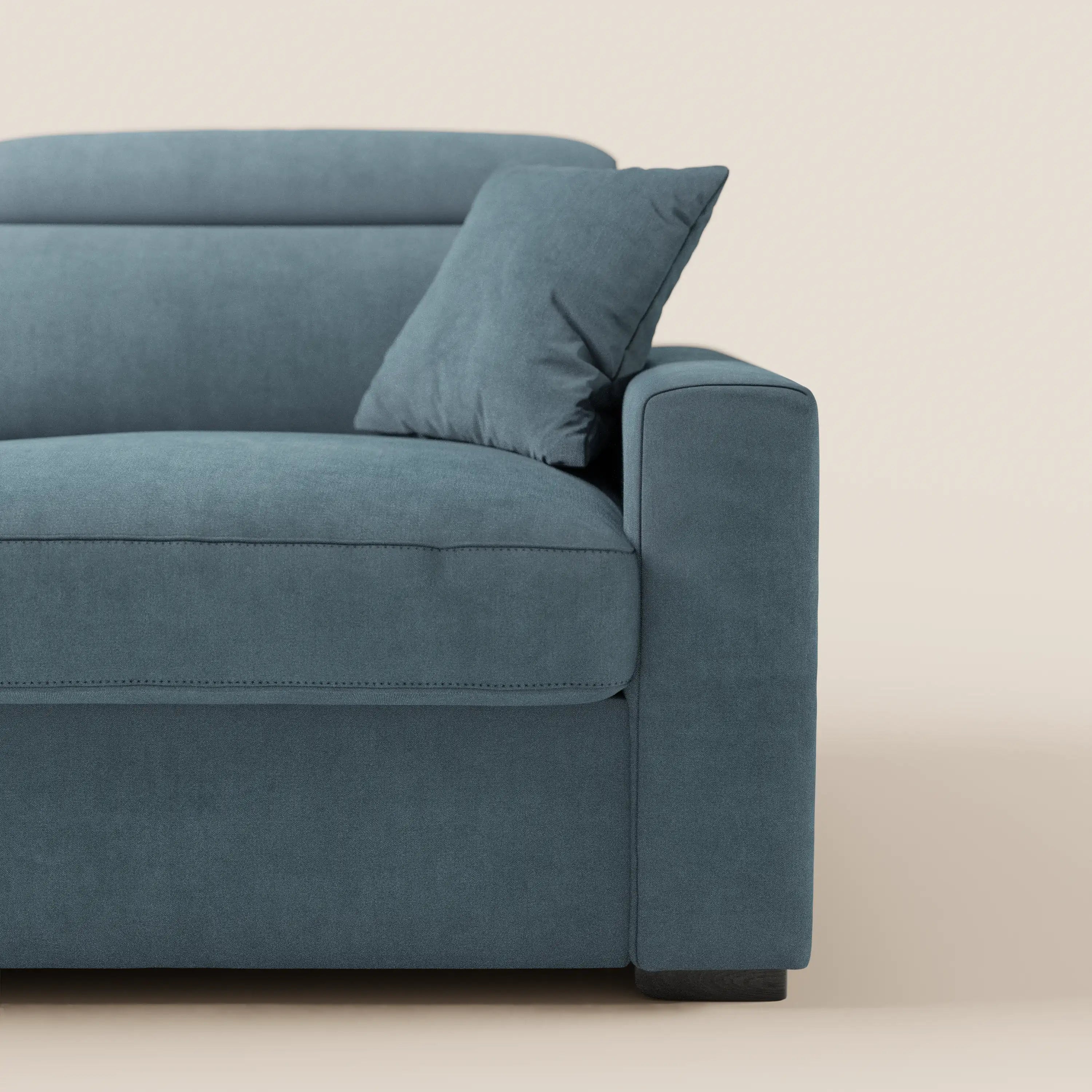 Un primo piano del lato destro del divano letto a 3 posti Maximus con materasso ALTO da 20 cm di Divani.Store, realizzato in tessuto blu Oeko-Tex antimacchia, con un cuscino, linee pulite, rivestimento morbido, schienale basso e poggiatesta reclinabili.