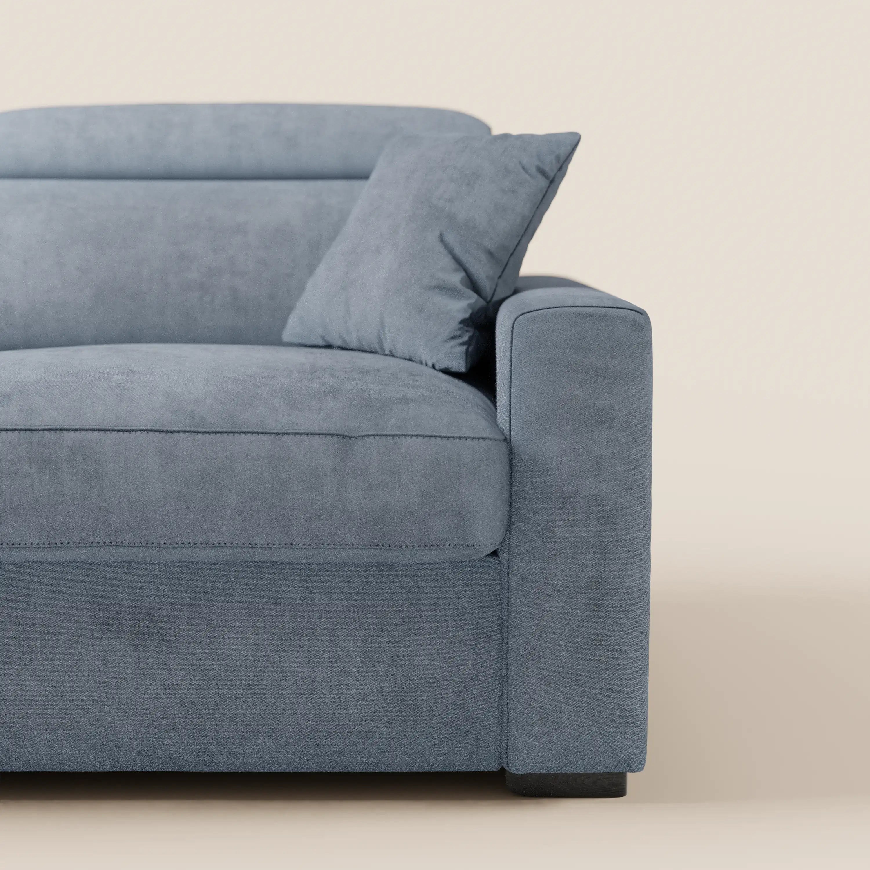 Un primo piano del divano letto Maximus a 3 posti con materasso ALTO 20 cm di Divani.Store, rivestito in moderno tessuto grigio smacchiabile Oeko-Tex, su uno sfondo beige a tinta unita. L'immagine mette in risalto il bracciolo destro, il cuscino della seduta, il cuscino dello schienale e un cuscino angolare abbinato. Questo divano si caratterizza per la trama morbida e soffice e le linee pulite e semplici ed è dotato di poggiatesta reclinabili per un comfort ancora maggiore.