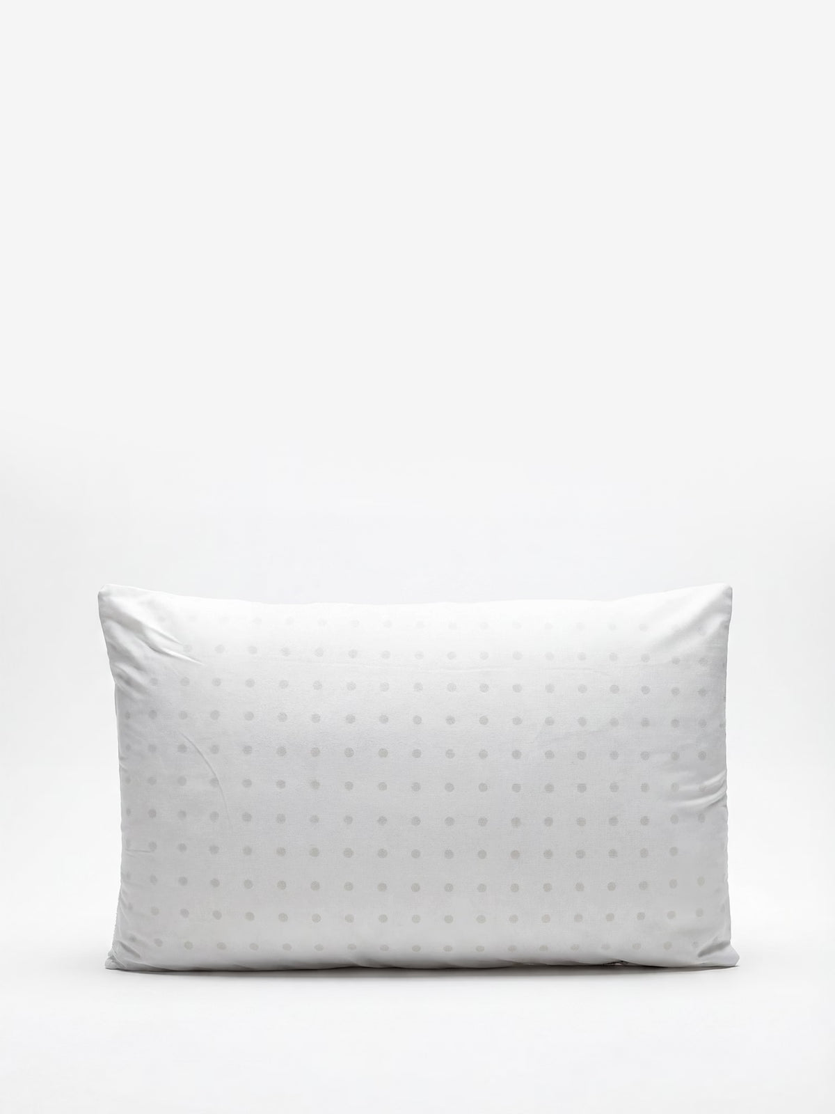 Un guanciale KYROS-PRIME in memory foam a iniezione, personalizzato e ortopedico, di Divani.Store è raffigurato su uno sfondo bianco uniforme. Il cuscino, caratterizzato da un delicato motivo a pois in bianco standard, appare morbido e leggermente stropicciato, con angoli arrotondati e bordi ben definiti, e offre un delicato sostegno cervicale per un comfort riposante. Nell’immagine non sono presenti altri oggetti o decorazioni.